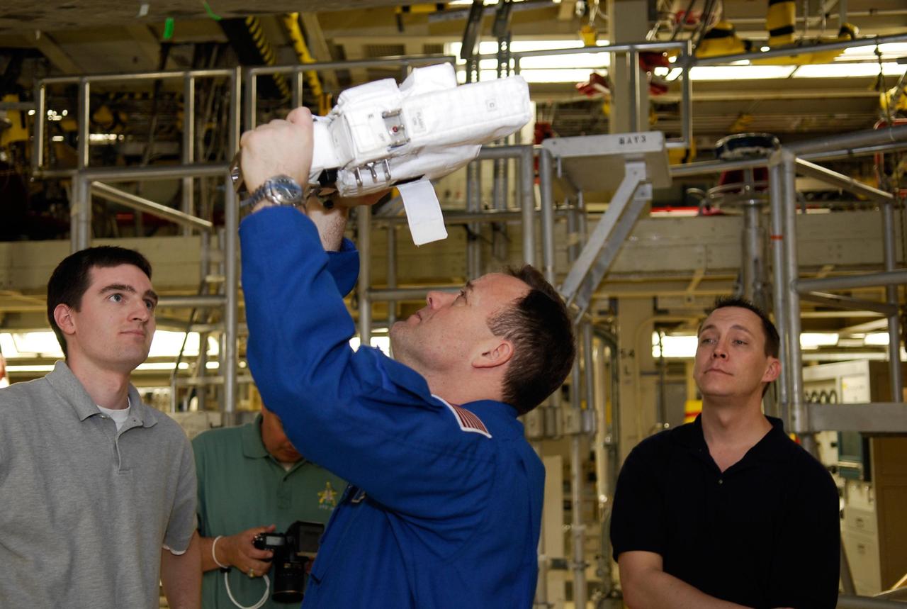 KENNEDY SPACE CENTER, FLA. -- During a crew equipment interface test in the Orbiter Processing Facility bay 3 at NASA's Kennedy Space Center, STS-124 Mission Specialist Ronald Garan practices focusing a camera on the underside of space shuttle Discovery. The camera will be used on the mission. Discovery will transport the Kibo Japanese Experiment Module - Pressurized Module (JEM-PM) and the Japanese Remote Manipulator System (JEM-RMS) to the International Space Station to complete the Kibo laboratory. The launch of Discovery is targeted for April 24. Photo credit: NASA/Kim Shiflett