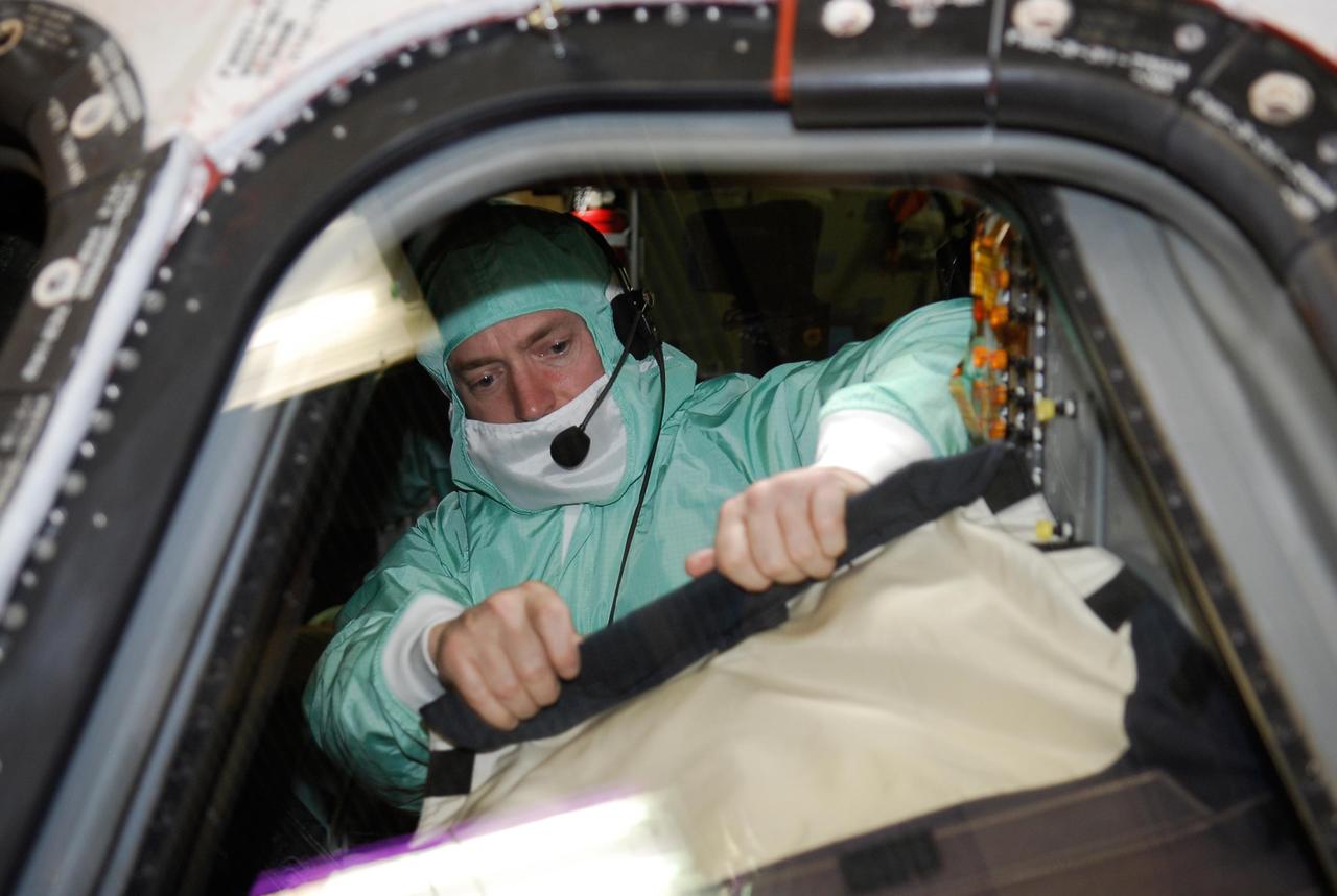 KENNEDY SPACE CENTER, FLA. -- During a crew equipment interface test in the Orbiter Processing Facility bay 3 at NASA's Kennedy Space Center, STS-124 Commander Mark Kelly closely examines a window in the cockpit of space shuttle Discovery.  The shuttle will transport the Kibo Japanese Experiment Module - Pressurized Module (JEM-PM) and the Japanese Remote Manipulator System (JEM-RMS) to the International Space Station to complete the Kibo laboratory.  The launch of Discovery is targeted for April 24.  Photo credit: NASA/Kim Shiflett