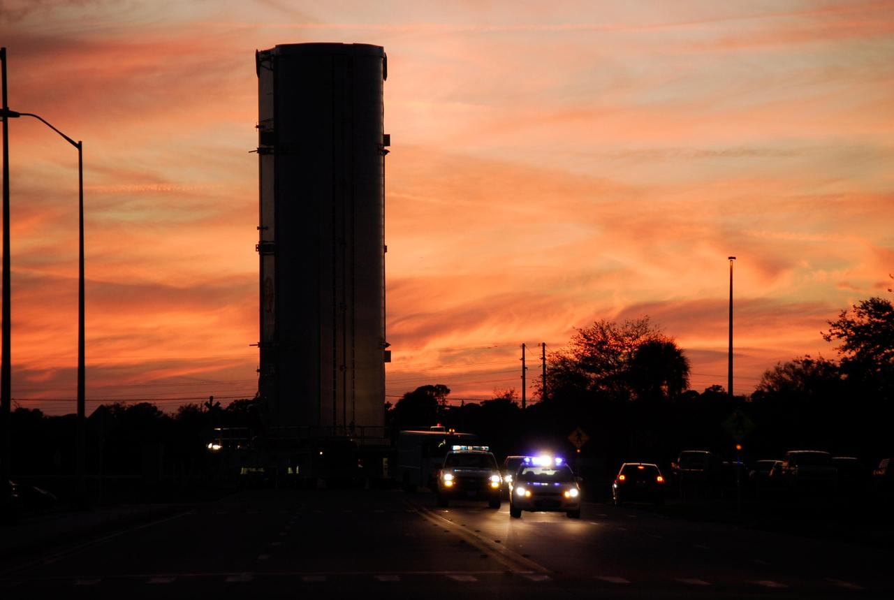 KENNEDY SPACE CENTER, FLA. --  At sunset, the payload canister containing the first section of the Japan Aerospace Exploration Agency's Kibo laboratory and the Canadian Space Agency's two-armed robotic system, Dextre, slowly moves toward Launch Pad 39A at NASA's Kennedy Space Center.  At the pad the payload will be transferred to the payload changeout room, part of the rotating service structure. The changeout room is the enclosed, environmentally controlled portion of the rotating service structure that supports cargo delivery to the pad and subsequent vertical installation into an orbiter's payload bay.  The payload will be installed into Endeavour for launch on the STS-123 mission targeted for March 11.  Photo credit: NASA/Kim Shiflett