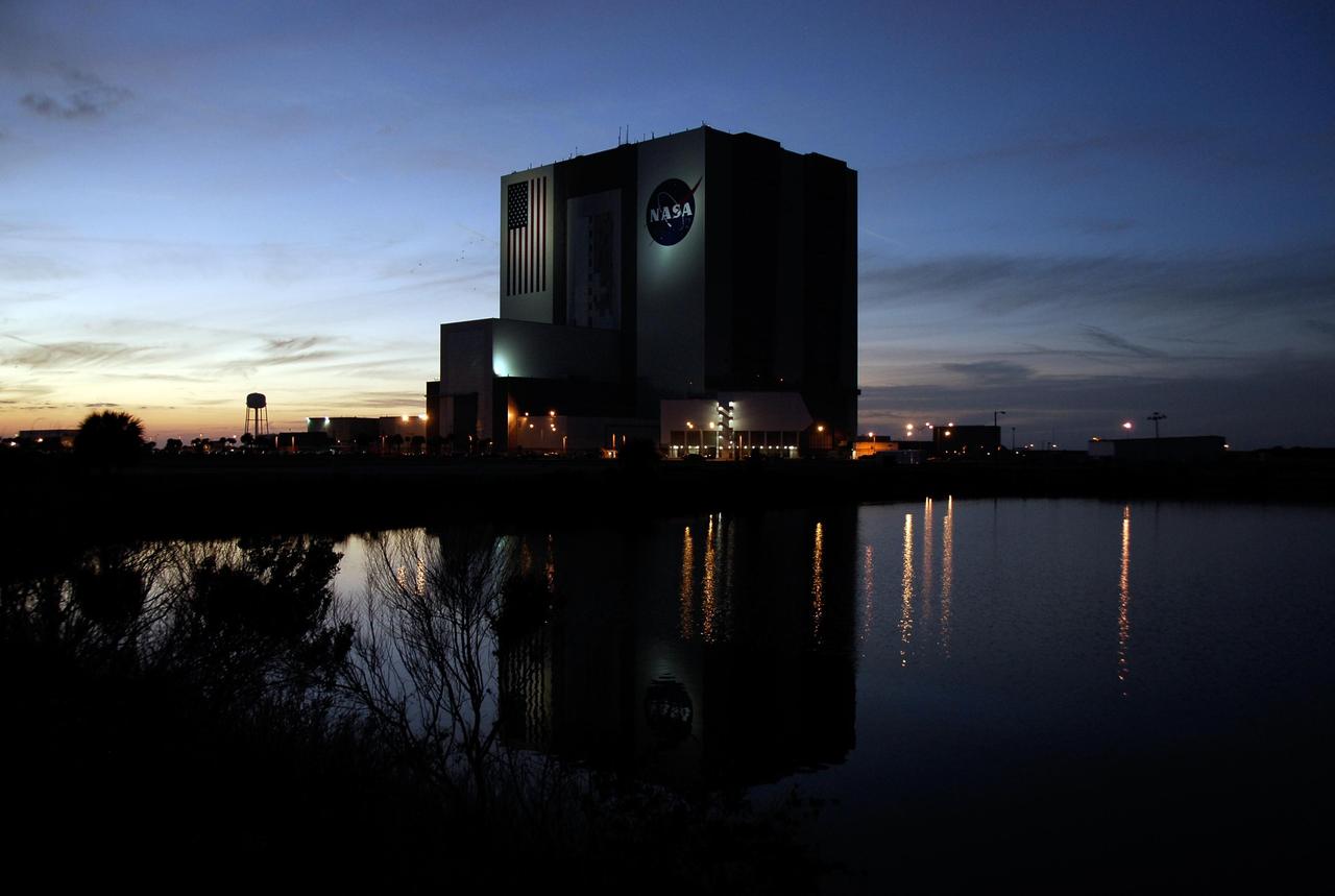 KENNEDY SPACE CENTER, FLA. --  The dark water of the turn basin at NASA's Kennedy Space Center mirrors the night lights and the Vehicle Assembly Building and Launch Control Center, silhouetted against the post-sunset sky.  Photo credit: NASA/Kim Shiflett