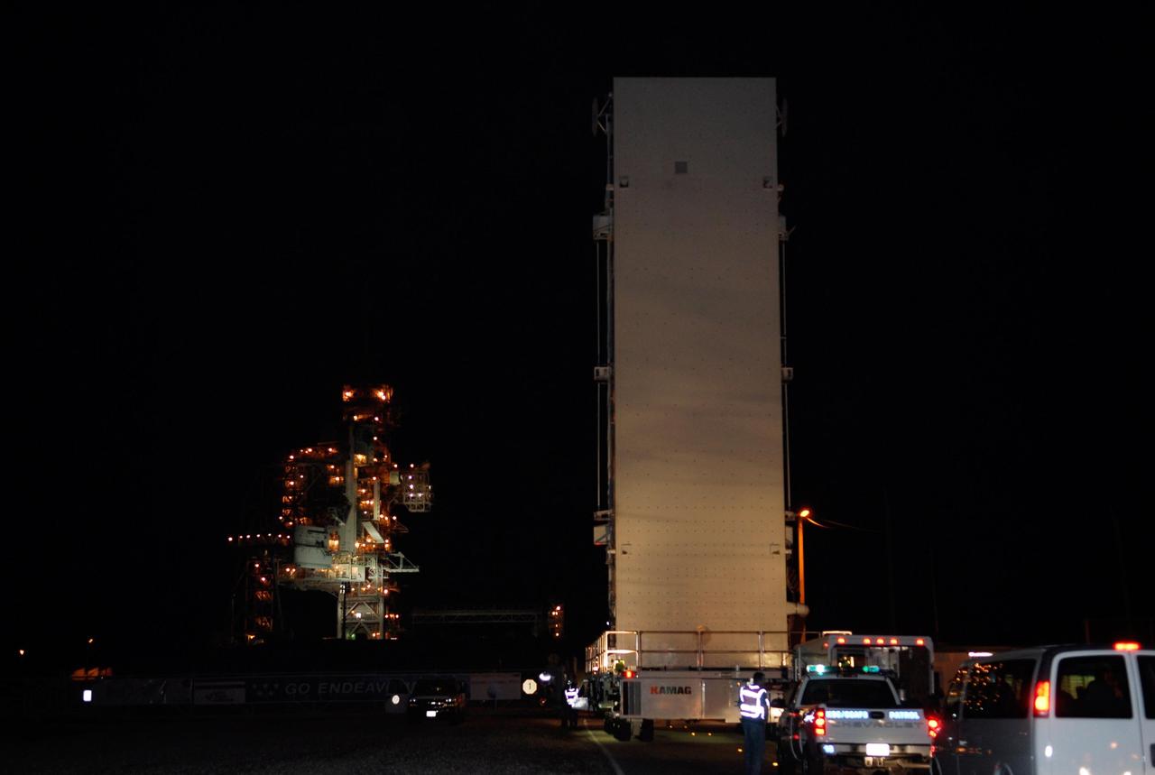 KENNEDY SPACE CENTER, FLA. --  The payload canister containing the first section of the Japan Aerospace Exploration Agency's Kibo laboratory and the Canadian Space Agency's two-armed robotic system, Dextre, moves toward Launch Pad 39A at NASA's Kennedy Space Center. At the pad the payload will be transferred to the payload changeout room, part of the rotating service structure. The changeout room is the enclosed, environmentally controlled portion of the rotating service structure that supports cargo delivery to the pad and subsequent vertical installation into an orbiter's payload bay.  The payload will be installed into Endeavour for launch on the STS-123 mission targeted for March 11.  Photo credit: NASA/Kim Shiflett