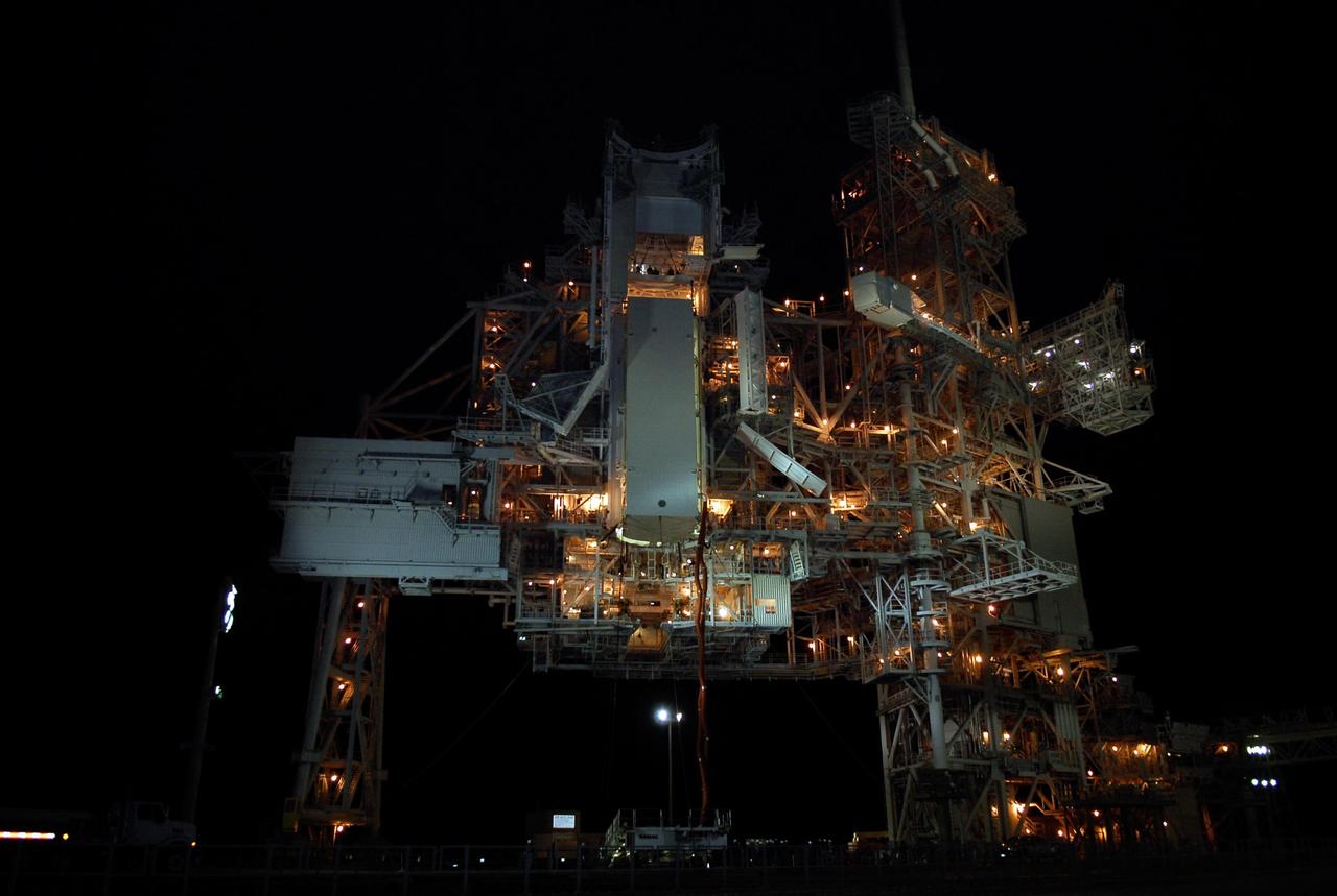 KENNEDY SPACE CENTER, FLA. --  On Launch Pad 39A at NASA's Kennedy Space Center, the payload canister containing the first section of the Japan Aerospace Exploration Agency's Kibo laboratory and the Canadian Space Agency's two-armed robotic system, Dextre, is lifted up toward the payload changeout room in the rotating service structure. Umbilical lines are still attached.   The changeout room is the enclosed, environmentally controlled portion of the rotating service structure that supports cargo delivery to the pad and subsequent vertical installation into an orbiter's payload bay.  The payload will be installed into Endeavour for launch on the STS-123 mission targeted for March 11.  Photo credit: NASA/Kim Shiflett