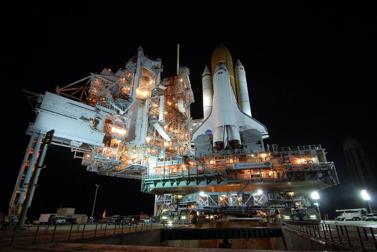 KENNEDY SPACE CENTER, FLA. -- Getting ready for the STS-123 mission, space shuttle Endeavour, atop the well-lighted mobile launcher platform, passes the rotating service structure (left) and flame trench (below) on Launch Pad 39A. The journey from the Vehicle Assembly Building began at 11:24 p.m. on Feb. 17, approximately 30 minutes before it's scheduled start time due to favorable weather conditions. The shuttle arrived at the launch pad at 4:45 a.m. Monday and was hard down at 6:22 a.m. On the mission, Endeavour and its crew will deliver the first section of the Japan Aerospace Exploration Agency's Kibo laboratory and the Canadian Space Agency's two-armed robotic system, Dextre. Launch is targeted for March 11. Photo credit: NASA/Amanda Diller