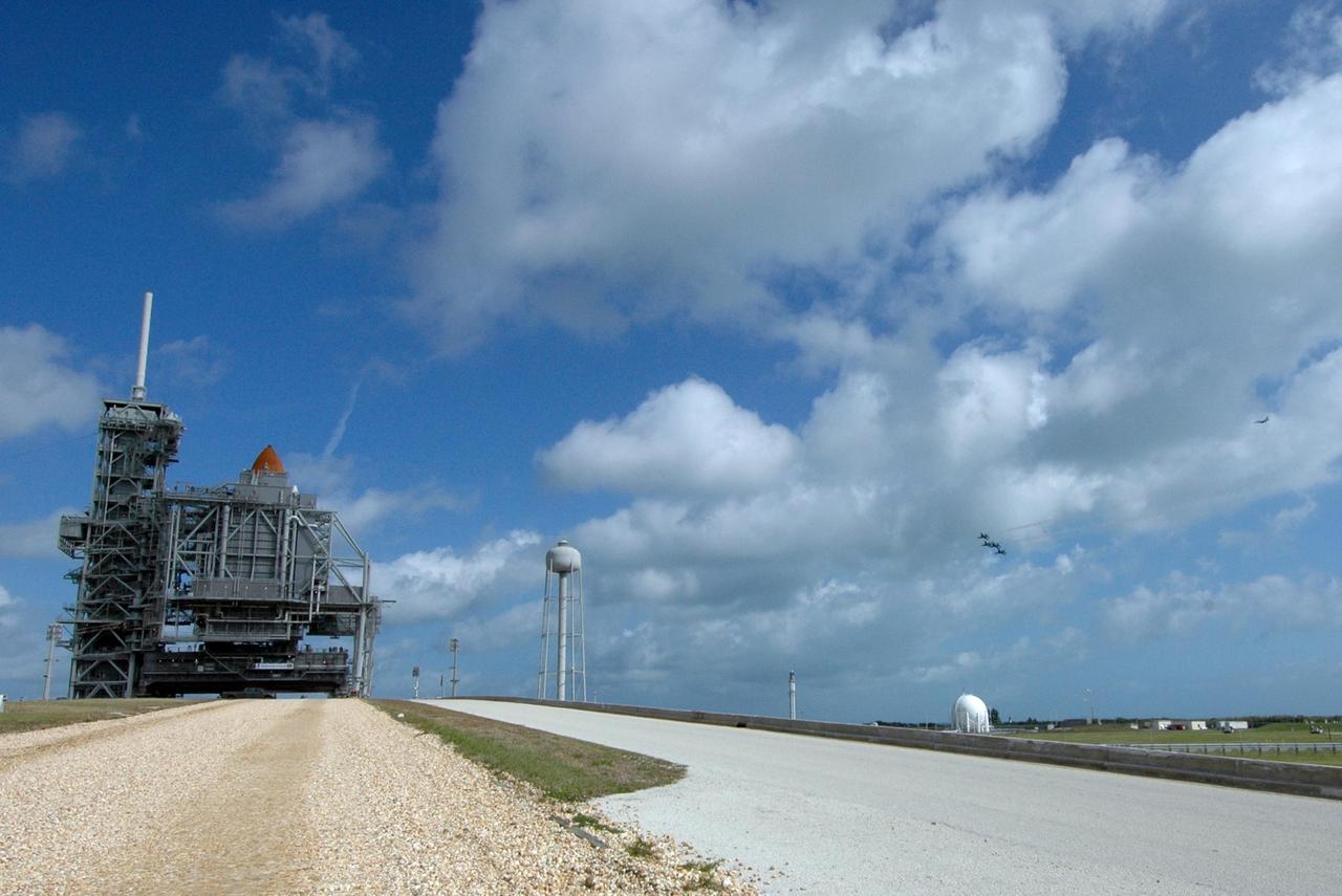 KENNEDY SPACE CENTER, FLA. --The U.S. Air Force Thunderbirds, at right, fly past Launch Pad 39A at NASA's Kennedy Space Center where space shuttle Endeavour waits to launch on the STS-123 mission.  At left, the rotating service structure has closed around the shuttle, with only the tip of the external tank showing. The aircraft had flown earlier to support the Daytona 500, also celebrating its 50th anniversary, and chose to fly over Kennedy on their way to their next assignment.  Endeavour is being prepared for launch on the STS-123 mission targeted for March 11.  Photo credit: NASA/Amanda Diller