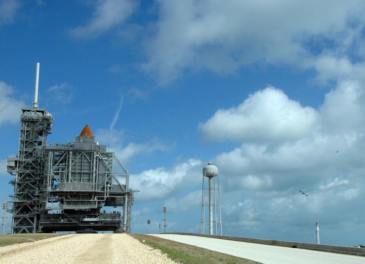 KENNEDY SPACE CENTER, FLA. --The U.S. Air Force Thunderbirds, at right, fly past Launch Pad 39A at NASA's Kennedy Space Center where space shuttle Endeavour waits to launch on the STS-123 mission.  At left, the rotating service structure has closed around the shuttle, with only the tip of the external tank showing in this view.  The aircraft had flown earlier to support the Daytona 500, also celebrating its 50th anniversary, and chose to fly over Kennedy on their way to their next assignment.  Endeavour is being prepared for launch on the STS-123 mission targeted for March 11.  Photo credit: NASA/Amanda Diller