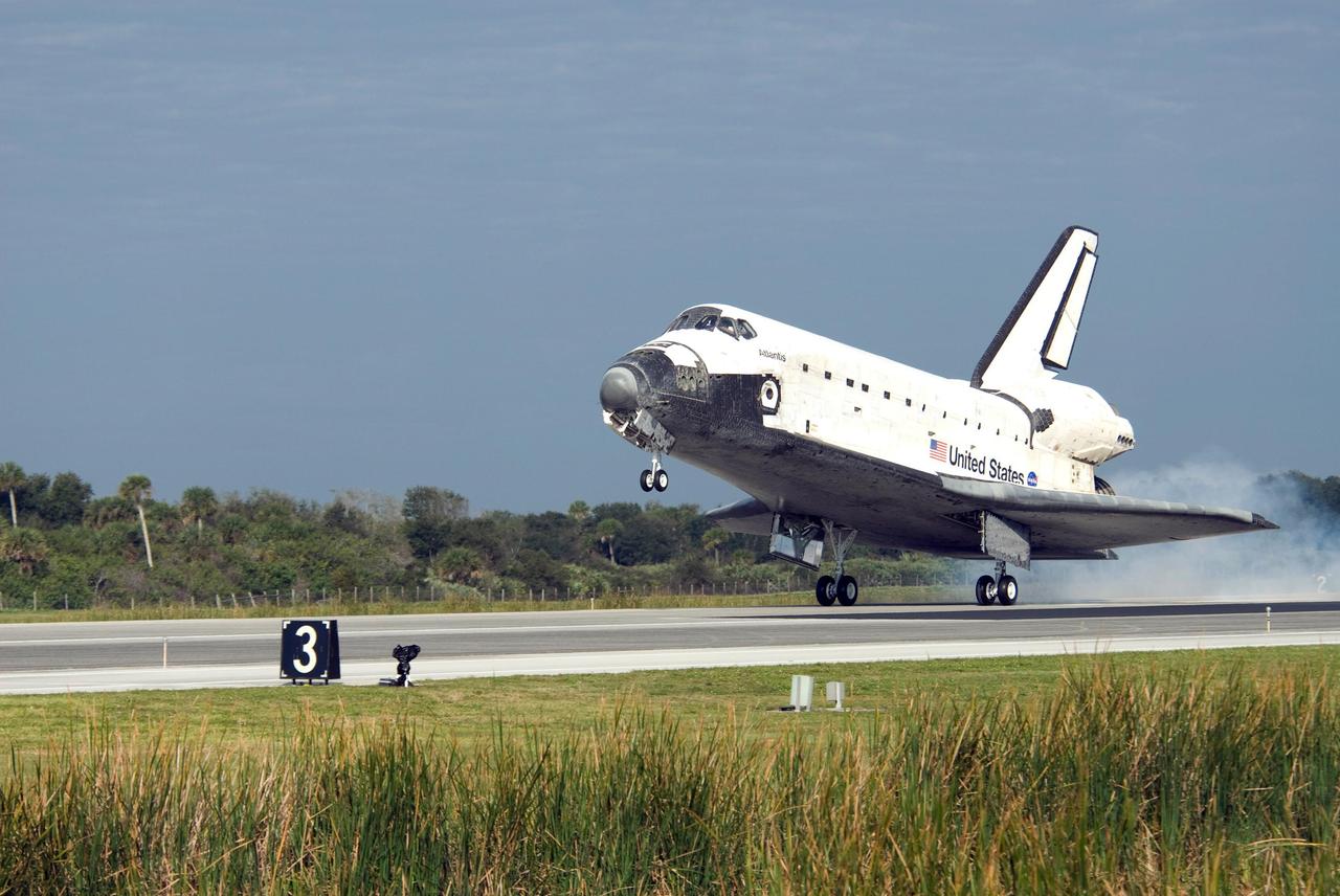 KENNEDY SPACE CENTER, FLA. -- Dust rises behind space shuttle Atlantis as the main landing gear touches down on Runway 15 of the Shuttle Landing Facility at NASA's Kennedy Space Center after a nearly 5.3 million mile round trip to the International Space Station. The shuttle landed on orbit 202 to complete the 13-day STS-122 mission. Main gear touchdown was 9:07:10 a.m. Nose gear touchdown was 9:07:20 a.m. Wheel stop was at 9:08:08 a.m. Mission elapsed time was 12 days, 18 hours, 21 minutes and 44 seconds. During the mission, Atlantis' crew installed the new Columbus laboratory, leaving a larger space station and one with increased science capabilities. The Columbus Research Module adds nearly 1,000 cubic feet of habitable volume and affords room for 10 experiment racks, each an independent science lab. Photo credit: NASA/Kevin O'Connell