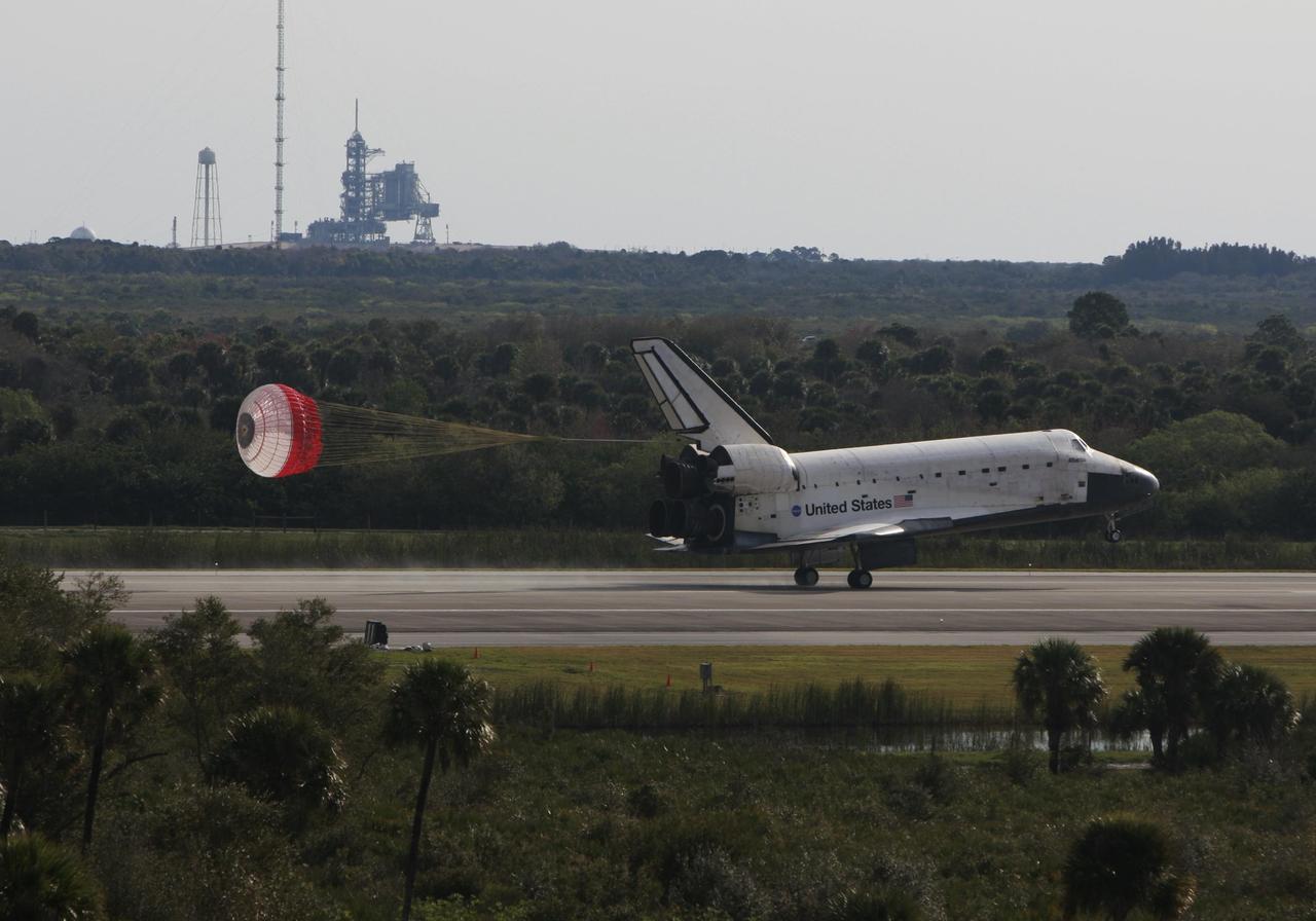 KENNEDY SPACE CENTER, FLA. -- With the aid of a drag chute, space shuttle Atlantis slows down after landing on Runway 15 of the Shuttle Landing Facility at NASA's Kennedy Space Center after a nearly 5.3 million mile round trip to the International Space Station. In the background is Launch Pad 39B. The shuttle landed on orbit 202 to complete the 13-day STS-122 mission. Main gear touchdown was 9:07:10 a.m. Nose gear touchdown was 9:07:20 a.m. Wheel stop was at 9:08:08 a.m. Mission elapsed time was 12 days, 18 hours, 21 minutes and 44 seconds. During the mission, Atlantis' crew installed the new Columbus laboratory, leaving a larger space station and one with increased science capabilities. The Columbus Research Module adds nearly 1,000 cubic feet of habitable volume and affords room for 10 experiment racks, each an independent science lab. Photo courtesy of Scott Andrews