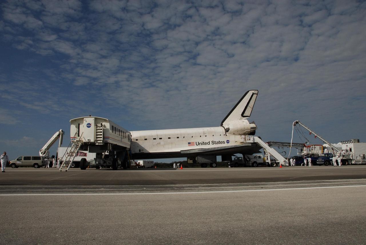 KENNEDY SPACE CENTER, FLA. --  On Runway 15 at NASA's Kennedy Space Center, the crew transport vehicle has drawn up to the crew hatch on space shuttle Atlantis after landing.  The crew transfers into the CTV to change from their launch and entry suits and later greet NASA VIPs and the media.  After a round trip of nearly 5.3 million miles, Atlantis and crew returned to Earth with a landing at 9:07 a.m. EST.The shuttle landed on orbit 202 to complete the 13-day STS-122 mission. Main gear touchdown was 9:07:10 a.m. Nose gear touchdown was 9:07:20 a.m. Wheel stop was at 9:08:08 a.m. Mission elapsed time was 12 days, 18 hours, 21 minutes and 44 seconds. During the mission, Atlantis' crew installed the new Columbus laboratory, leaving a larger space station and one with increased science capabilities. The Columbus Research Module adds nearly 1,000 cubic feet of habitable volume and affords room for 10 experiment racks, each an independent science lab. Photo credit: NASA/Jack Pfaller