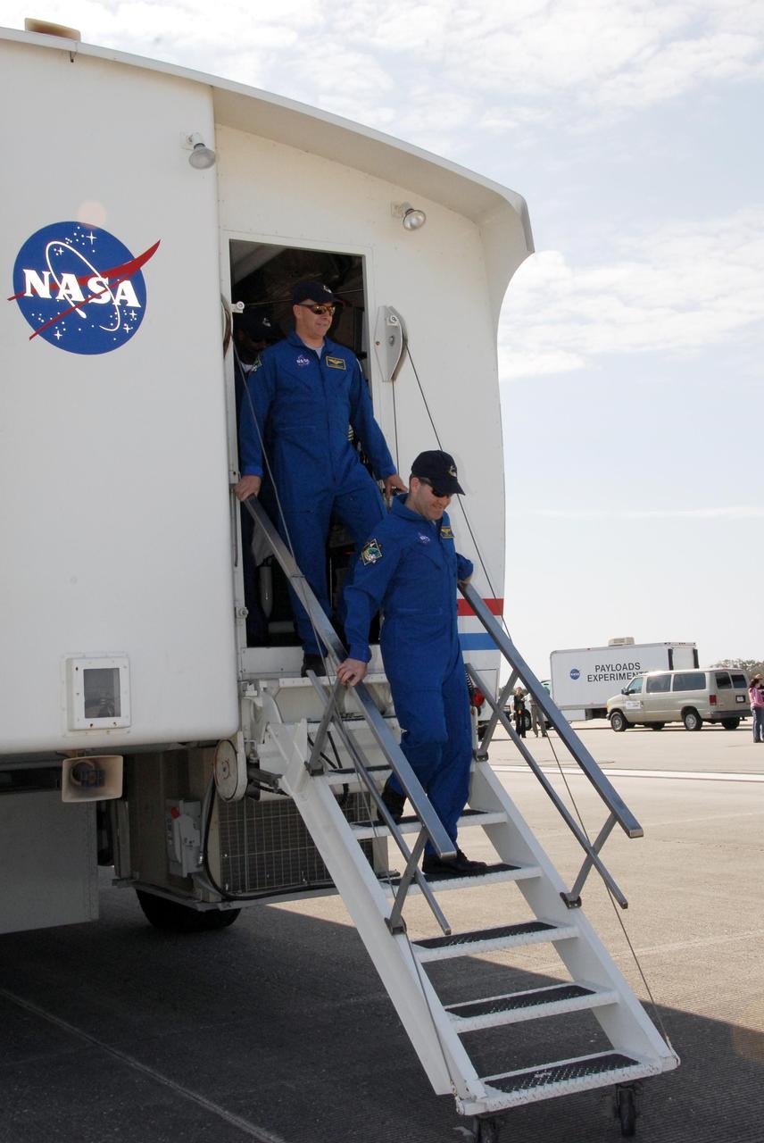 KENNEDY SPACE CENTER, FLA. -- At the Shuttle Landing Facility at NASA's Kennedy Space Center, STS-122 Commander Steve Frick (right) and Pilot Alan Poindexter exit the crew transport vehicle. After a round trip of nearly 5.3 million miles, space shuttle Atlantis and crew returned to Earth with a landing at 9:07 a.m. EST. The shuttle landed on orbit 202 to complete the 13-day STS-122 mission. Main gear touchdown was 9:07:10 a.m. Nose gear touchdown was 9:07:20 a.m. Wheel stop was at 9:08:08 a.m. Mission elapsed time was 12 days, 18 hours, 21 minutes and 44 seconds. During the mission, Atlantis' crew installed the new Columbus laboratory, leaving a larger space station and one with increased science capabilities. The Columbus Research Module adds nearly 1,000 cubic feet of habitable volume and affords room for 10 experiment racks, each an independent science lab. Photo credit: NASA/Jack Pfaller