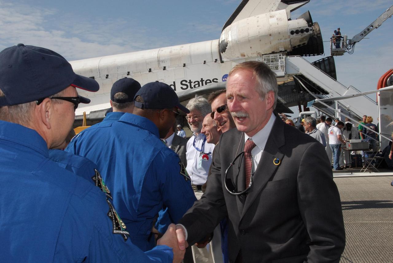 KENNEDY SPACE CENTER, FLA. --  After exiting the crew transport vehicle, STS-122 crew members are greeted by NASA Associate Administrator for Space Operations William Gerstenmaier (right) and Director of Mission Launch Integration LeRoy Cain (second from right).  After a round trip of nearly 5.3 million miles, space shuttle Atlantis and crew returned to Earth with a landing at 9:07 a.m. EST.  The shuttle landed on orbit 202 to complete the 13-day STS-122 mission. Main gear touchdown was 9:07:10 a.m. Nose gear touchdown was 9:07:20 a.m. Wheel stop was at 9:08:08 a.m. Mission elapsed time was 12 days, 18 hours, 21 minutes and 44 seconds. During the mission, Atlantis' crew installed the new Columbus laboratory, leaving a larger space station and one with increased science capabilities. The Columbus Research Module adds nearly 1,000 cubic feet of habitable volume and affords room for 10 experiment racks, each an independent science lab. Photo credit: NASA/Jack Pfaller