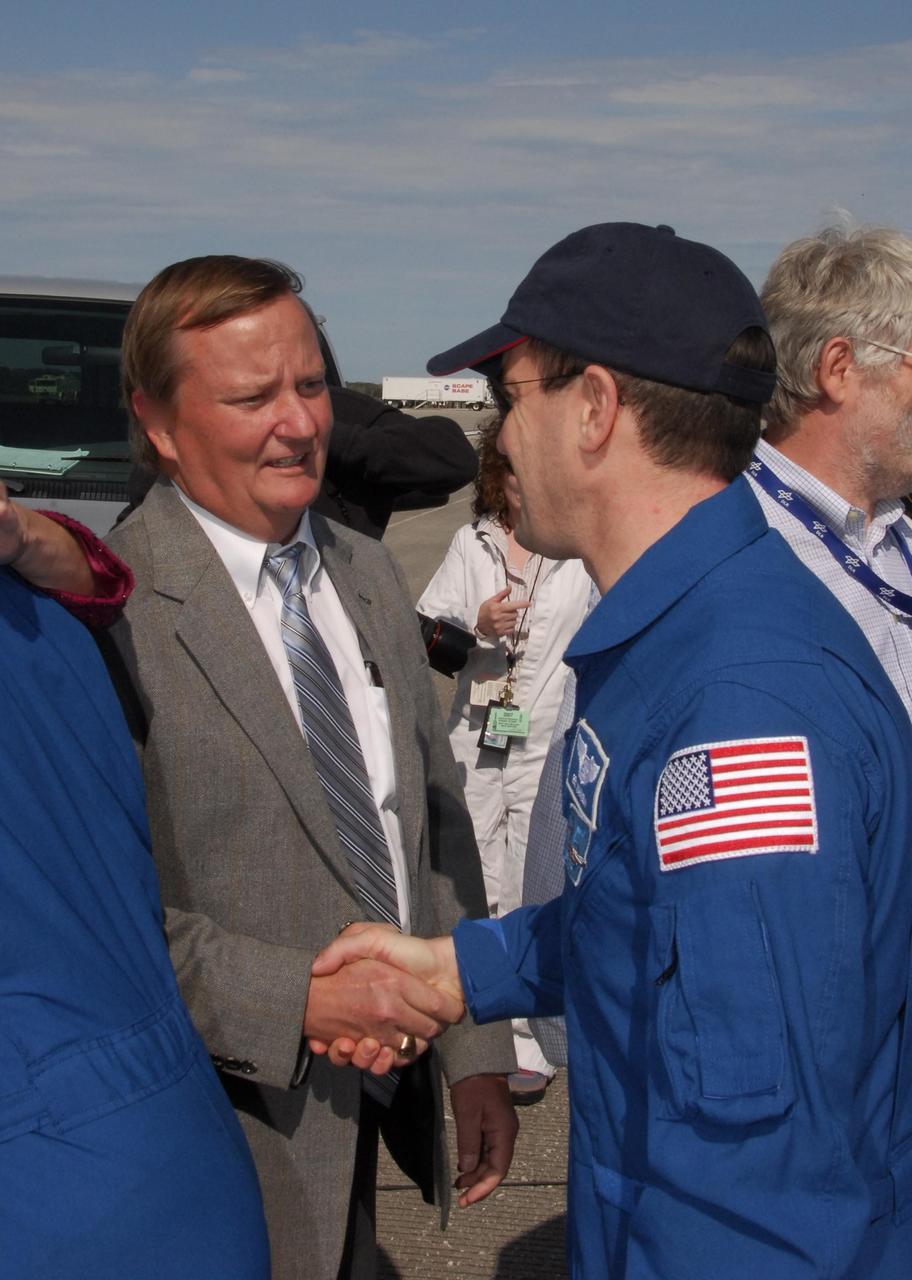 KENNEDY SPACE CENTER, FLA. -- After exiting the crew transport vehicle, STS-122 Mission Specialist Rex Walheim is welcomed by Shuttle Launch Director Mike Leinbach. After a round trip of nearly 5.3 million miles, space shuttle Atlantis and crew returned to Earth with a landing at 9:07 a.m. EST. The shuttle landed on orbit 202 to complete the 13-day STS-122 mission. Main gear touchdown was 9:07:10 a.m. Nose gear touchdown was 9:07:20 a.m. Wheel stop was at 9:08:08 a.m. Mission elapsed time was 12 days, 18 hours, 21 minutes and 44 seconds. During the mission, Atlantis' crew installed the new Columbus laboratory, leaving a larger space station and one with increased science capabilities. The Columbus Research Module adds nearly 1,000 cubic feet of habitable volume and affords room for 10 experiment racks, each an independent science lab. Photo credit: NASA/Jack Pfaller
