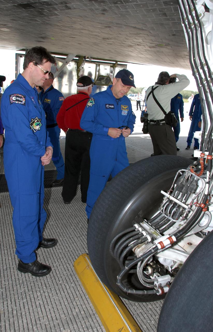 KENNEDY SPACE CENTER, FLA. -- After exiting the crew transport vehicle, STS-122 Mission Specialists Rex Walheim and Hans Schlegel check the tire on space shuttle Atlantis' landing gear. After a round trip of nearly 5.3 million miles, space shuttle Atlantis and crew returned to Earth with a landing at 9:07 a.m. EST. The shuttle landed on orbit 202 to complete the 13-day STS-122 mission. Main gear touchdown was 9:07:10 a.m. Nose gear touchdown was 9:07:20 a.m. Wheel stop was at 9:08:08 a.m. Mission elapsed time was 12 days, 18 hours, 21 minutes and 44 seconds. During the mission, Atlantis' crew installed the new Columbus laboratory, leaving a larger space station and one with increased science capabilities. The Columbus Research Module adds nearly 1,000 cubic feet of habitable volume and affords room for 10 experiment racks, each an independent science lab. Photo credit: NASA/Jack Pfaller