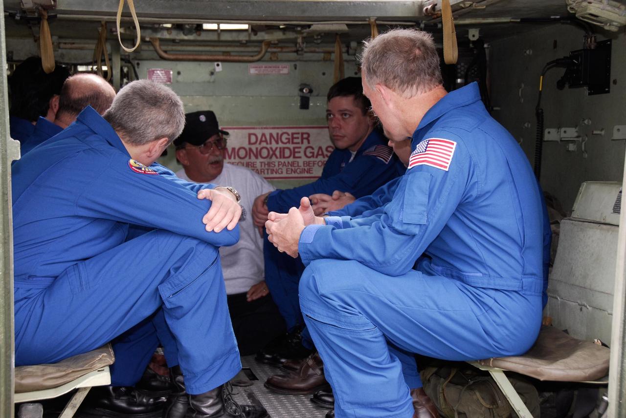 KENNEDY SPACE CENTER, FLA. -- At NASA Kennedy Space Center's Launch Complex 39, STS-123 crew members are instructed on the use of the M-113 armored personnel carrier from Capt. George Hoggard, astronaut rescue team leader.  The crew members of space shuttle Endeavour's STS-123 mission will each practice driving the M-113 in turn as part of his training on emergency egress procedures.      An M-113 will be available to transport the crew to safety in the event of a contingency on the pad before their launch.  The STS-123 crew is at Kennedy for a full launch dress rehearsal, known as the terminal countdown demonstration test or TCDT.  Endeavour's seven astronauts arrived at Kennedy's Shuttle Landing Facility in their T-38 training aircraft between 10:45 and 10:58 a.m. EST. The terminal countdown demonstration test provides astronauts and ground crews with an opportunity to participate in various simulated countdown activities, including equipment familiarization and emergency training. Endeavour is targeted to launch March 11 at 2:28 a.m. EDT on a 16-day mission to the International Space Station. On the mission, Endeavour and its crew will deliver the first section of the Japan Aerospace Exploration Agency's Kibo laboratory and the Canadian Space Agency's two-armed robotic system, Dextre. Photo credit: NASA/Kim Shiflett