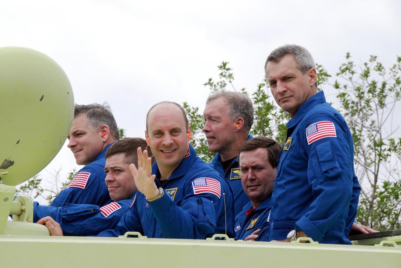 KENNEDY SPACE CENTER, FLA. -- At NASA Kennedy Space Center's Launch Complex 39, members of space shuttle Endeavour's STS-123 mission practice driving the M-113 armored personnel carrier.  The crew members of space shuttle Endeavour's STS-123 mission will each practice driving the M-113 in turn as part of his training on emergency egress procedures.  From left are Pilot Gregory H. Johnson; Mission Specialists Robert L. Behnken and Garrett Reisman; Commander Dominic Gorie; and Mission Specialists Mike Foreman and Rick Linnehan.      An M-113 will be available to transport the crew to safety in the event of a contingency on the pad before their launch.  The STS-123 crew is at Kennedy for a full launch dress rehearsal, known as the terminal countdown demonstration test or TCDT.  Endeavour's seven astronauts arrived at Kennedy's Shuttle Landing Facility in their T-38 training aircraft between 10:45 and 10:58 a.m. EST. The terminal countdown demonstration test provides astronauts and ground crews with an opportunity to participate in various simulated countdown activities, including equipment familiarization and emergency training. Endeavour is targeted to launch March 11 at 2:28 a.m. EDT on a 16-day mission to the International Space Station. On the mission, Endeavour and its crew will deliver the first section of the Japan Aerospace Exploration Agency's Kibo laboratory and the Canadian Space Agency's two-armed robotic system, Dextre. Photo credit: NASA/Kim Shiflett
