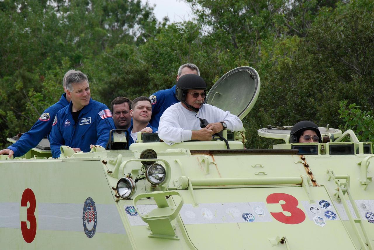 KENNEDY SPACE CENTER, FLA. -- At NASA Kennedy Space Center's Launch Complex 39, astronaut rescue team leader Capt. George Hoggard, in the white sweatshirt, instructs members of the crew for space shuttle Endeavour's STS-123 mission on the operation of an M-113 armored personnel carrier.  Each member of the crew will practice driving the M-113 in turn as part of his training on emergency egress procedures.  An M-113 will be available to transport the crew to safety in the event of a contingency on the pad before their launch.  The STS-123 crew is at Kennedy for a full launch dress rehearsal, known as the terminal countdown demonstration test or TCDT.  Endeavour's seven astronauts arrived at Kennedy's Shuttle Landing Facility in their T-38 training aircraft between 10:45 and 10:58 a.m. EST. The terminal countdown demonstration test provides astronauts and ground crews with an opportunity to participate in various simulated countdown activities, including equipment familiarization and emergency training. Endeavour is targeted to launch March 11 at 2:28 a.m. EDT on a 16-day mission to the International Space Station. On the mission, Endeavour and its crew will deliver the first section of the Japan Aerospace Exploration Agency's Kibo laboratory and the Canadian Space Agency's two-armed robotic system, Dextre. Photo credit: NASA/Kim Shiflett