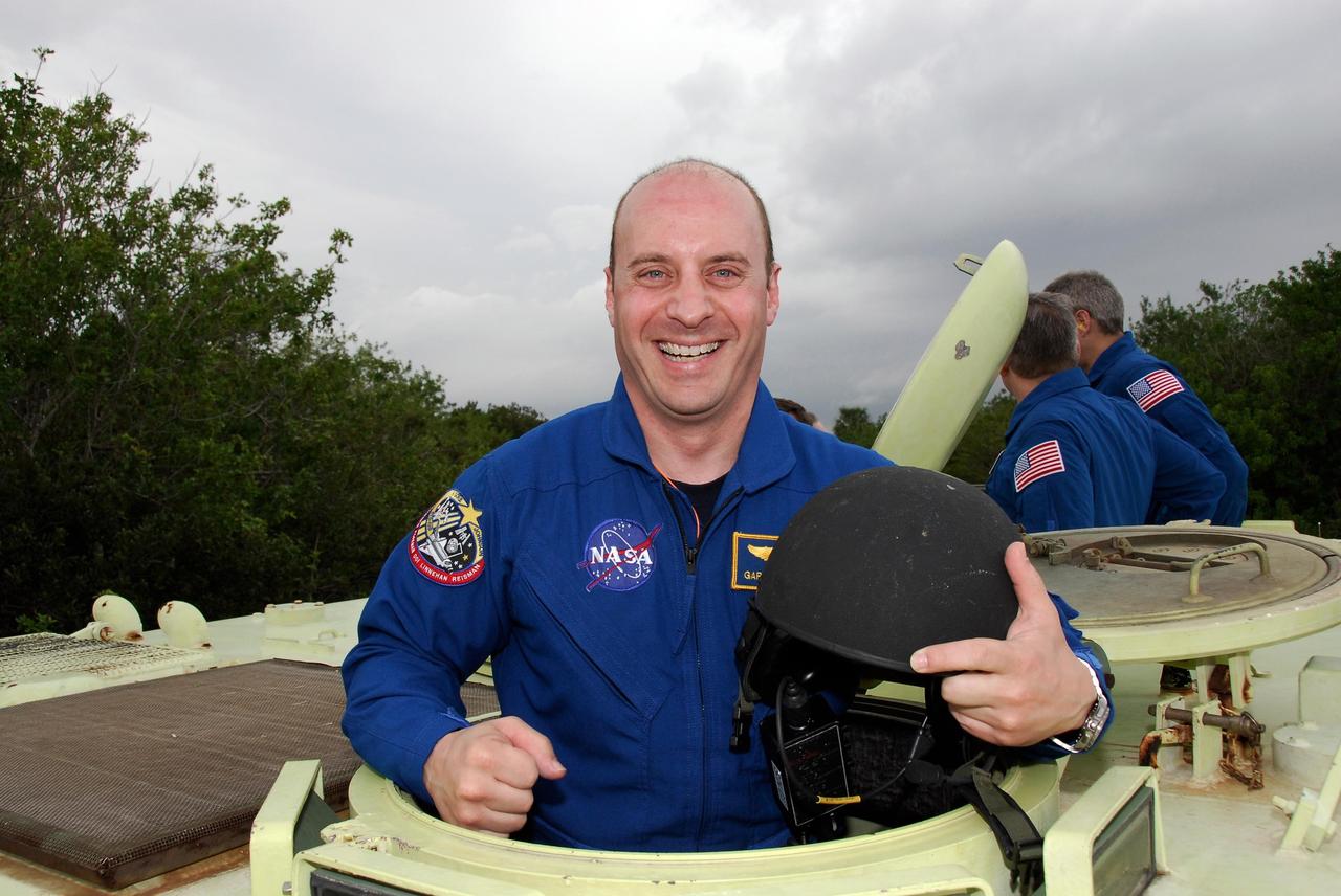 KENNEDY SPACE CENTER, FLA. -- At NASA Kennedy Space Center's Launch Complex 39,  STS-123 Mission Specialist Garrett Reisman takes time out from driving practice of the M-113 armored personnel carrier to pose for a photo.  The crew members of space shuttle Endeavour's STS-123 mission will each practice driving the M-113 in turn as part of his training on emergency egress procedures.  Reisman will remain on the International Space Station as a flight engineer on the Expedition 16 and 17 crews.  An M-113 will be available to transport the crew to safety in the event of a contingency on the pad before their launch.  The STS-123 crew is at Kennedy for a full launch dress rehearsal, known as the terminal countdown demonstration test or TCDT.  Endeavour's seven astronauts arrived at Kennedy's Shuttle Landing Facility in their T-38 training aircraft between 10:45 and 10:58 a.m. EST. The terminal countdown demonstration test provides astronauts and ground crews with an opportunity to participate in various simulated countdown activities, including equipment familiarization and emergency training. Endeavour is targeted to launch March 11 at 2:28 a.m. EDT on a 16-day mission to the International Space Station. On the mission, Endeavour and its crew will deliver the first section of the Japan Aerospace Exploration Agency's Kibo laboratory and the Canadian Space Agency's two-armed robotic system, Dextre. Photo credit: NASA/Kim Shiflett