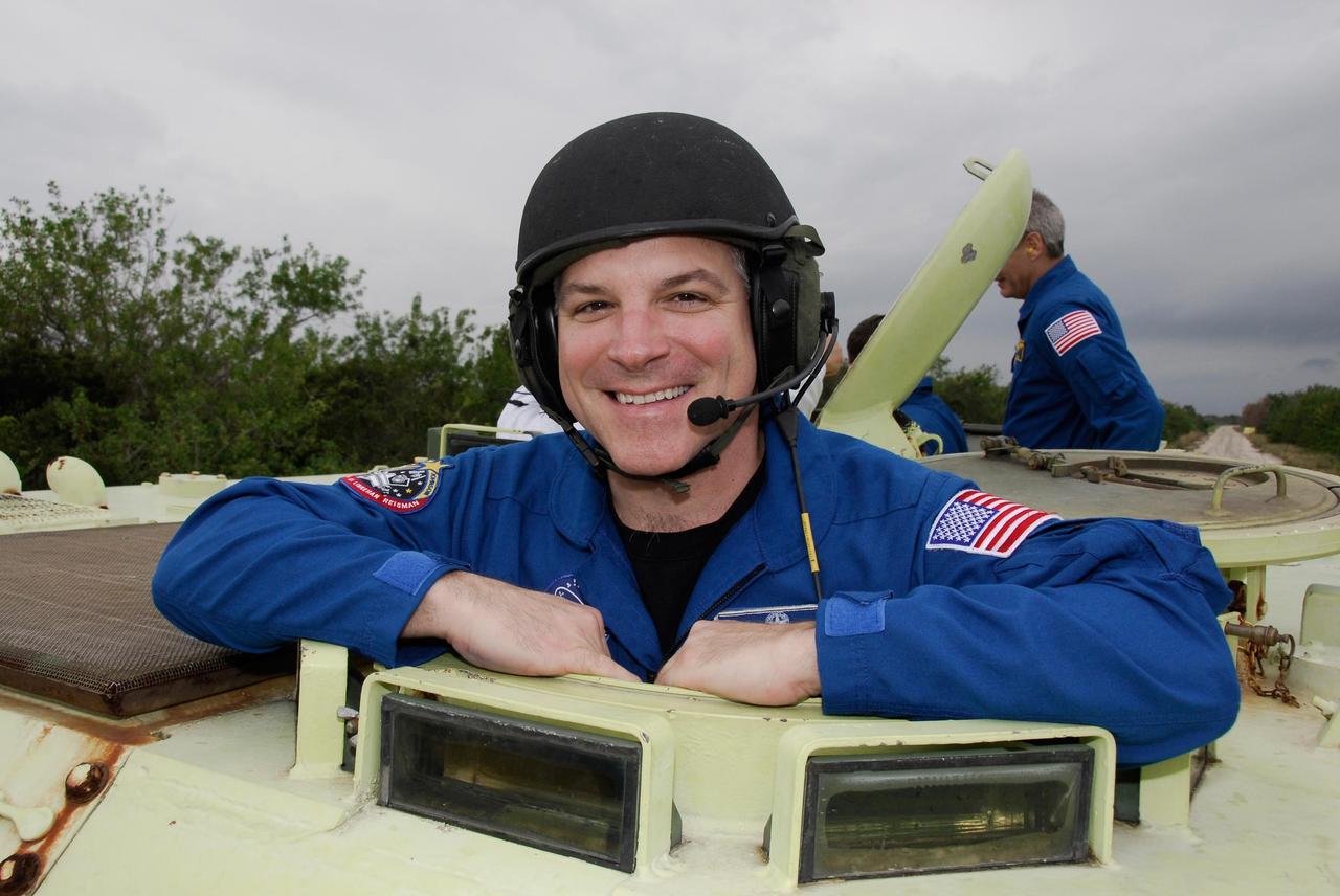 KENNEDY SPACE CENTER, FLA. -- At NASA Kennedy Space Center's Launch Complex 39, STS-123 Pilot Gregory H. Johnson takes time out from driving practice of the M-113 armored personnel carrier to pose for a photo.  The crew members of space shuttle Endeavour's STS-123 mission will each practice driving the M-113 in turn as part of his training on emergency egress procedures.  An M-113 will be available to transport the crew to safety in the event of a contingency on the pad before their launch.  The STS-123 crew is at Kennedy for a full launch dress rehearsal, known as the terminal countdown demonstration test or TCDT.  Endeavour's seven astronauts arrived at Kennedy's Shuttle Landing Facility in their T-38 training aircraft between 10:45 and 10:58 a.m. EST. The terminal countdown demonstration test provides astronauts and ground crews with an opportunity to participate in various simulated countdown activities, including equipment familiarization and emergency training. Endeavour is targeted to launch March 11 at 2:28 a.m. EDT on a 16-day mission to the International Space Station. On the mission, Endeavour and its crew will deliver the first section of the Japan Aerospace Exploration Agency's Kibo laboratory and the Canadian Space Agency's two-armed robotic system, Dextre. Photo credit: NASA/Kim Shiflett