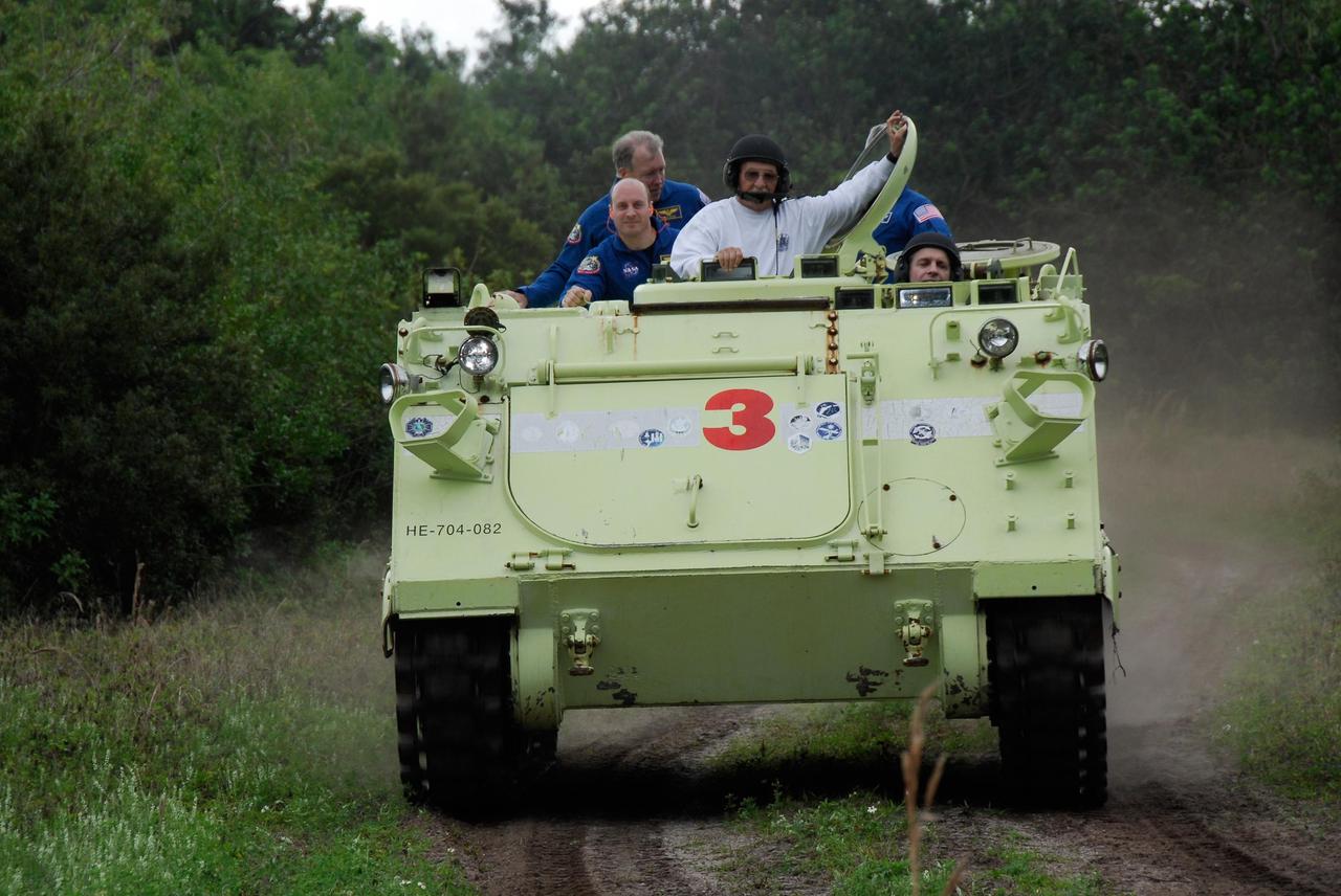 KENNEDY SPACE CENTER, FLA. -- At NASA Kennedy Space Center's Launch Complex 39, astronaut rescue team leader Capt. George Hoggard, in the white sweatshirt, instructs members of the crew for space shuttle Endeavour's STS-123 mission on the operation of an M-113 armored personnel carrier.  The crew members of space shuttle Endeavour's STS-123 mission will each practice driving the M-113 in turn as part of his training on emergency egress procedures.  An M-113 will be available to transport the crew to safety in the event of a contingency on the pad before their launch.  The STS-123 crew is at Kennedy for a full launch dress rehearsal, known as the terminal countdown demonstration test or TCDT.  Endeavour's seven astronauts arrived at Kennedy's Shuttle Landing Facility in their T-38 training aircraft between 10:45 and 10:58 a.m. EST. The terminal countdown demonstration test provides astronauts and ground crews with an opportunity to participate in various simulated countdown activities, including equipment familiarization and emergency training. Endeavour is targeted to launch March 11 at 2:28 a.m. EDT on a 16-day mission to the International Space Station. On the mission, Endeavour and its crew will deliver the first section of the Japan Aerospace Exploration Agency's Kibo laboratory and the Canadian Space Agency's two-armed robotic system, Dextre. Photo credit: NASA/Kim Shiflett