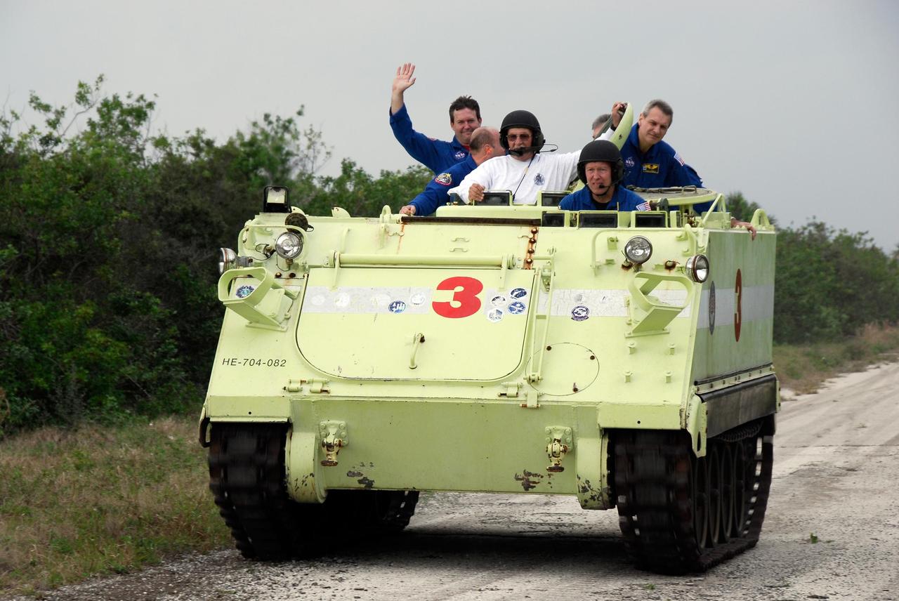 KENNEDY SPACE CENTER, FLA. -- At NASA Kennedy Space Center's Launch Complex 39, STS-123 Commander Dominic Gorie practices driving the M-113 armored personnel carrier.  Behind him are, from left, STS-123 Mission Specialists Mike Foreman and Garrett Reisman, astronaut rescue team leader Capt. George Hoggard, STS-123 Pilot Gregory H. Johnson and STS-123 Mission Specialist Rick Linnehan.  The crew members of space shuttle Endeavour's STS-123 mission will each practice driving the M-113 in turn as part of his training on emergency egress procedures.  An M-113 will be available to transport the crew to safety in the event of a contingency on the pad before their launch.  The STS-123 crew is at Kennedy for a full launch dress rehearsal, known as the terminal countdown demonstration test or TCDT.  Endeavour's seven astronauts arrived at Kennedy's Shuttle Landing Facility in their T-38 training aircraft between 10:45 and 10:58 a.m. EST. The terminal countdown demonstration test provides astronauts and ground crews with an opportunity to participate in various simulated countdown activities, including equipment familiarization and emergency training. Endeavour is targeted to launch March 11 at 2:28 a.m. EDT on a 16-day mission to the International Space Station. On the mission, Endeavour and its crew will deliver the first section of the Japan Aerospace Exploration Agency's Kibo laboratory and the Canadian Space Agency's two-armed robotic system, Dextre. Photo credit: NASA/Kim Shiflett