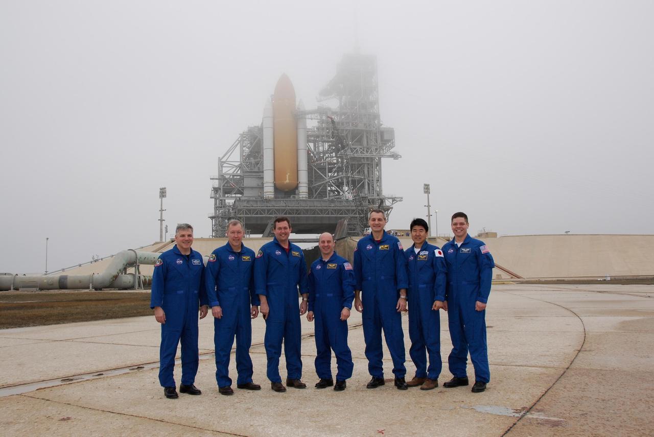 KENNEDY SPACE CENTER, FLA. -- At NASA Kennedy Space Center's Launch Pad 39A, the crew for space shuttle Endeavour's STS-123 mission takes time out from training activities to pose for a group portrait. From left are Pilot Gregory H. Johnson; Commander Dominic Gorie and Mission Specialists Mike Foreman, Garrett Reisman, Rick Linnehan, Takao Doi of the Japan Aerospace Exploration Agency and Robert L. Behnken. Endeavour is on the pad in the background. The crew is at Kennedy for a full launch dress rehearsal, known as the terminal countdown demonstration test or TCDT. The terminal countdown demonstration test provides astronauts and ground crews with an opportunity to participate in various simulated countdown activities, including equipment familiarization and emergency training. Endeavour is targeted to launch March 11 at 2:28 a.m. EDT on a 16-day mission to the International Space Station. On the mission, Endeavour and its crew will deliver the first section of the Japan Aerospace Exploration Agency's Kibo laboratory and the Canadian Space Agency's two-armed robotic system, Dextre. Photo credit: NASA/Kim Shiflett