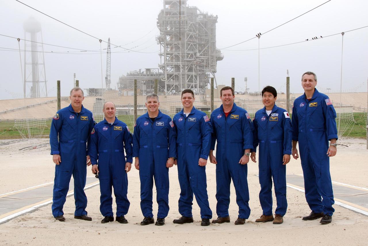 KENNEDY SPACE CENTER, FLA. -- At NASA Kennedy Space Center's Launch Pad 39A, the crew for space shuttle Endeavour's STS-123 mission poses for a group portrait following a question-and-answer session with the media. From left are Commander Dominic Gorie; Mission Specialist Garrett Reisman; Pilot Gregory H. Johnson; and Mission Specialists Robert L. Behnken, Mike Foreman, Takao Doi of the Japan Aerospace Exploration Agency and Rick Linnehan. Endeavour is on the pad in the background. The crew is at Kennedy for a full launch dress rehearsal, known as the terminal countdown demonstration test or TCDT. The terminal countdown demonstration test provides astronauts and ground crews with an opportunity to participate in various simulated countdown activities, including equipment familiarization and emergency training. Endeavour is targeted to launch March 11 at 2:28 a.m. EDT on a 16-day mission to the International Space Station. On the mission, Endeavour and its crew will deliver the first section of the Japan Aerospace Exploration Agency's Kibo laboratory and the Canadian Space Agency's two-armed robotic system, Dextre. Photo credit: NASA/Kim Shiflett
