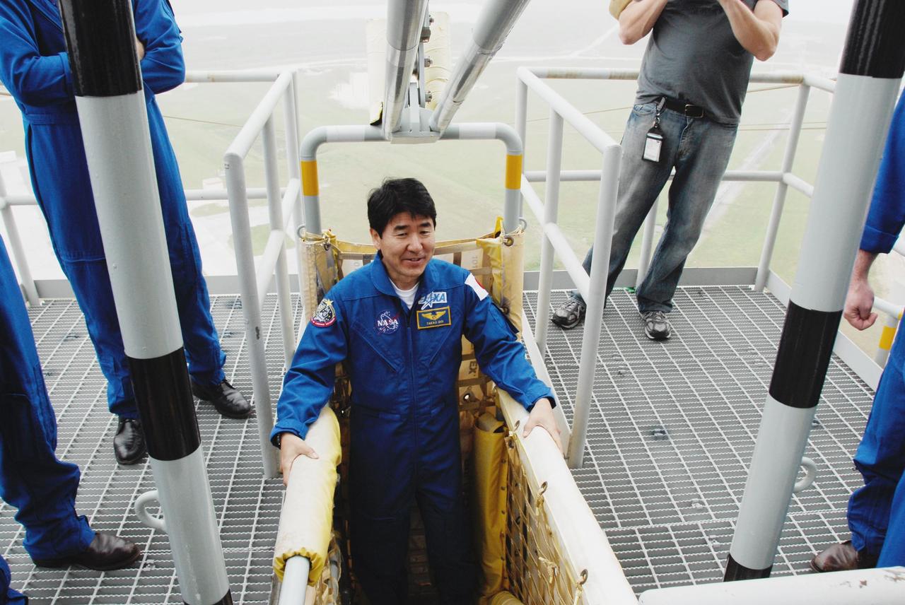 KENNEDY SPACE CENTER, FLA. -- At NASA Kennedy Space Center's Launch Pad 39A, STS-123 Mission Specialist Takao Doi of the Japan Aerospace Exploration Agency receives instruction on the operation of a slidewire basket during emergency egress training. The crew is at Kennedy for a full launch dress rehearsal, known as the terminal countdown demonstration test or TCDT. The terminal countdown demonstration test provides astronauts and ground crews with an opportunity to participate in various simulated countdown activities, including equipment familiarization and emergency training. Endeavour is targeted to launch March 11 at 2:28 a.m. EDT on a 16-day mission to the International Space Station. On the mission, Endeavour and its crew will deliver the first section of the Japan Aerospace Exploration Agency's Kibo laboratory and the Canadian Space Agency's two-armed robotic system, Dextre. Photo credit: NASA/Kim Shiflett