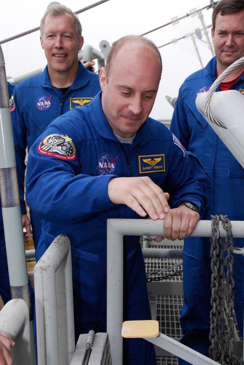 KENNEDY SPACE CENTER, FLA. -- At NASA Kennedy Space Center's Launch Pad 39A, STS-123 Mission Specialist Garrett Reisman receives instruction on the operation of a slidewire basket during emergency egress training as Commander Dominic Gorie and Mission Specialist Mike Foreman look on. Reisman will remain on the International Space Station as a flight engineer on the Expedition 16 and 17 crews. The crew is at Kennedy for a full launch dress rehearsal, known as the terminal countdown demonstration test or TCDT. The terminal countdown demonstration test provides astronauts and ground crews with an opportunity to participate in various simulated countdown activities, including equipment familiarization and emergency training. Endeavour is targeted to launch March 11 at 2:28 a.m. EDT on a 16-day mission to the International Space Station. On the mission, Endeavour and its crew will deliver the first section of the Japan Aerospace Exploration Agency's Kibo laboratory and the Canadian Space Agency's two-armed robotic system, Dextre. Photo credit: NASA/Kim Shiflett