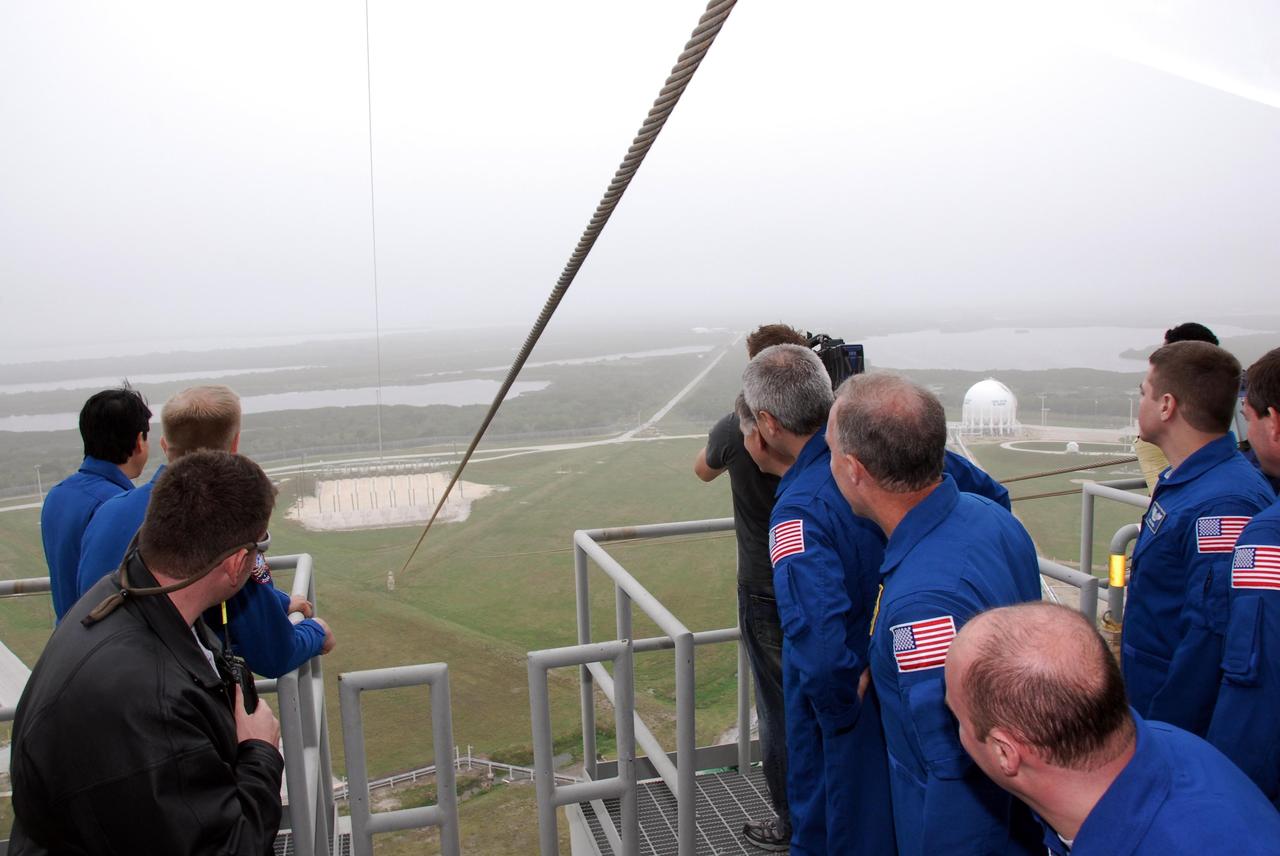 KENNEDY SPACE CENTER, FLA. -- At NASA Kennedy Space Center's Launch Pad 39A, the crew for space shuttle Endeavour's STS-123 mission views the landing site at the base of the pad for the slidewire baskets during emergency egress training. The crew is at Kennedy for a full launch dress rehearsal, known as the terminal countdown demonstration test or TCDT. The terminal countdown demonstration test provides astronauts and ground crews with an opportunity to participate in various simulated countdown activities, including equipment familiarization and emergency training. Endeavour is targeted to launch March 11 at 2:28 a.m. EDT on a 16-day mission to the International Space Station. On the mission, Endeavour and its crew will deliver the first section of the Japan Aerospace Exploration Agency's Kibo laboratory and the Canadian Space Agency's two-armed robotic system, Dextre. Photo credit: NASA/Kim Shiflett