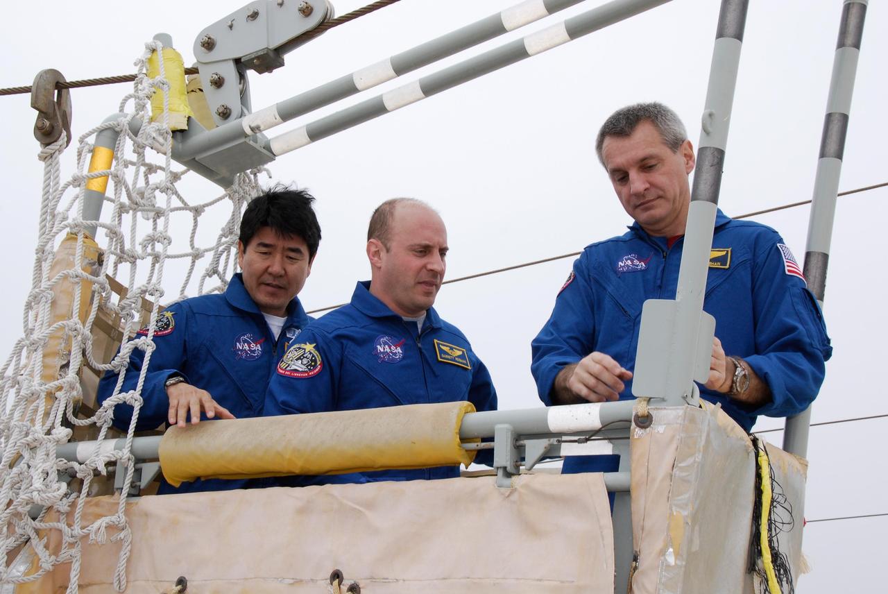 KENNEDY SPACE CENTER, FLA. -- At NASA Kennedy Space Center's Launch Pad 39A, the crew for space shuttle Endeavour's STS-123 mission receives instruction on the operation of a slidewire basket during emergency egress training. In the basket are Mission Specialists Takao Doi of the Japan Aerospace Exploration Agency, Garrett Reisman and Rick Linnehan. The crew is at Kennedy for a full launch dress rehearsal, known as the terminal countdown demonstration test or TCDT. The terminal countdown demonstration test provides astronauts and ground crews with an opportunity to participate in various simulated countdown activities, including equipment familiarization and emergency training. Endeavour is targeted to launch March 11 at 2:28 a.m. EDT on a 16-day mission to the International Space Station. On the mission, Endeavour and its crew will deliver the first section of the Japan Aerospace Exploration Agency's Kibo laboratory and the Canadian Space Agency's two-armed robotic system, Dextre. Photo credit: NASA/Kim Shiflett