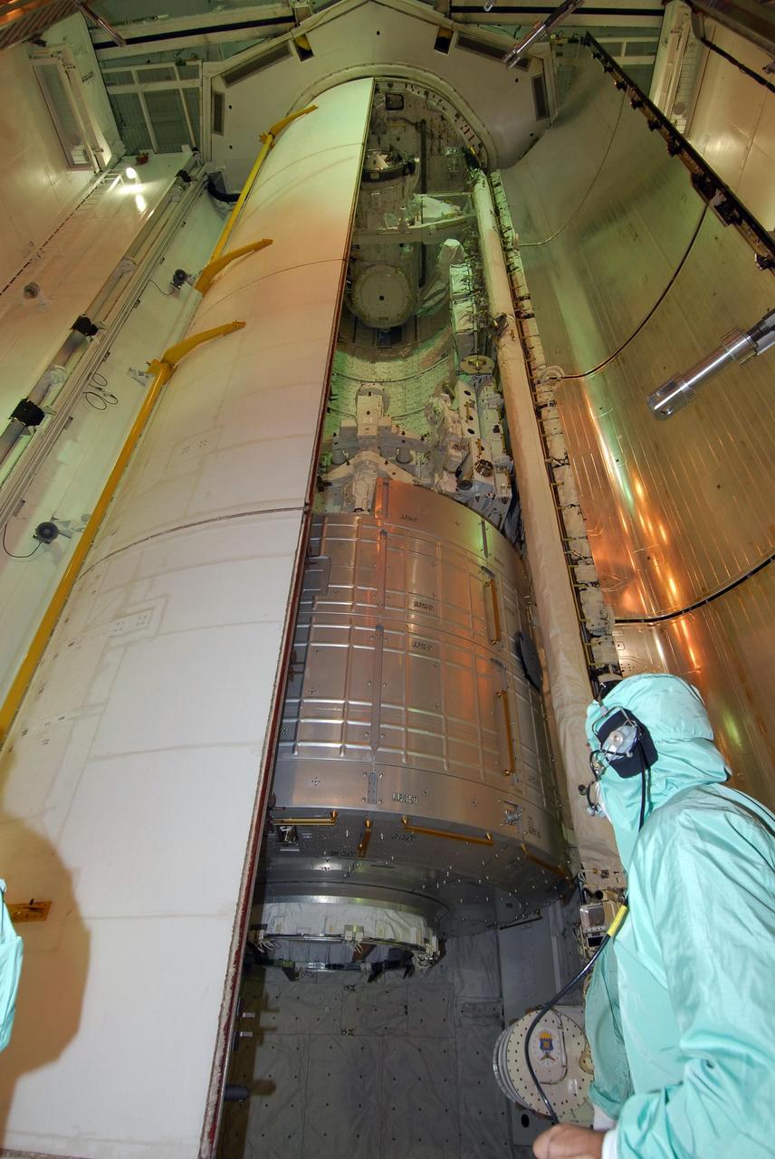KENNEDY SPACE CENTER, FLA. --   On NASA Kennedy Space Center's Launch Pad 39A, a worker stands by as one of space shuttle Endeavour's payload bay doors closes.  Still seen, at the bottom of the payload bay, is the first section of the Japan Aerospace Exploration Agency's Kibo laboratory, the Experiment Logistics Module Pressurized Section, or ELM-PS.  Endeavour is targeted to launch March 11 at 2:28 a.m. EDT on the 16-day STS-123 mission to the International Space Station. Endeavour and its crew will deliver the ELM-PS and the Canadian Space Agency's two-armed robotic system, Dextre.   Photo credit: NASA/Dimitri Gerondidakis
