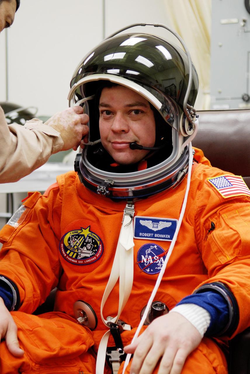 KENNEDY SPACE CENTER, FLA. --   STS-123 Mission Specialist Robert L. Behnken dons his helmet while suiting up for the launch dress rehearsal, culmination of the terminal countdown demonstration test, or TCDT.  The TCDT provides astronauts and ground crews with an opportunity to participate in various simulated countdown activities, including equipment familiarization and emergency training. Space shuttle Endeavour is targeted to launch March 11 at 2:28 a.m. EDT on the 16-day STS-123 mission to the International Space Station.  Endeavour and its crew will deliver the first section of the Japan Aerospace Exploration Agency's Kibo laboratory and the Canadian Space Agency's two-armed robotic system, Dextre.   Photo credit: NASA/Kim Shiflett