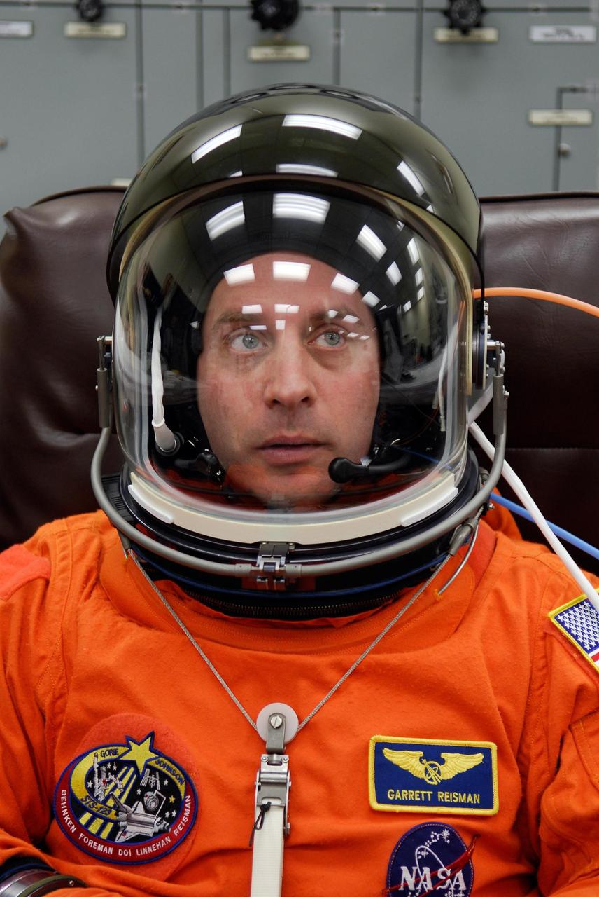 KENNEDY SPACE CENTER, FLA. --  STS-123 Mission Specialist Garrett Reisman tests the communications in his helmet while suiting up for the launch dress rehearsal, culmination of the terminal countdown demonstration test, or TCDT. The TCDT provides astronauts and ground crews with an opportunity to participate in various simulated countdown activities, including equipment familiarization and emergency training. Space shuttle Endeavour is targeted to launch March 11 at 2:28 a.m. EDT on the 16-day STS-123 mission to the International Space Station.  Endeavour and its crew will deliver the first section of the Japan Aerospace Exploration Agency's Kibo laboratory and the Canadian Space Agency's two-armed robotic system, Dextre.   Photo credit: NASA/Kim Shiflett
