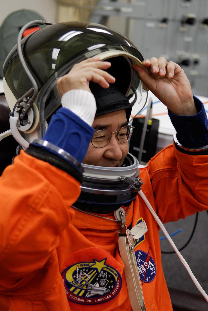 KENNEDY SPACE CENTER, FLA. --  STS-123 Mission Specialist Takao Doi tries on his helmet during suitup for the launch dress rehearsal, culmination of the terminal countdown demonstration test, or TCDT. Doi represents the Japan Aerospace Exploration Agency, or JAXA.  The TCDT provides astronauts and ground crews with an opportunity to participate in various simulated countdown activities, including equipment familiarization and emergency training. Space shuttle Endeavour is targeted to launch March 11 at 2:28 a.m. EDT on the 16-day STS-123 mission to the International Space Station.  Endeavour and its crew will deliver the first section of the Japan Aerospace Exploration Agency's Kibo laboratory and the Canadian Space Agency's two-armed robotic system, Dextre.   Photo credit: NASA/Kim Shiflett
