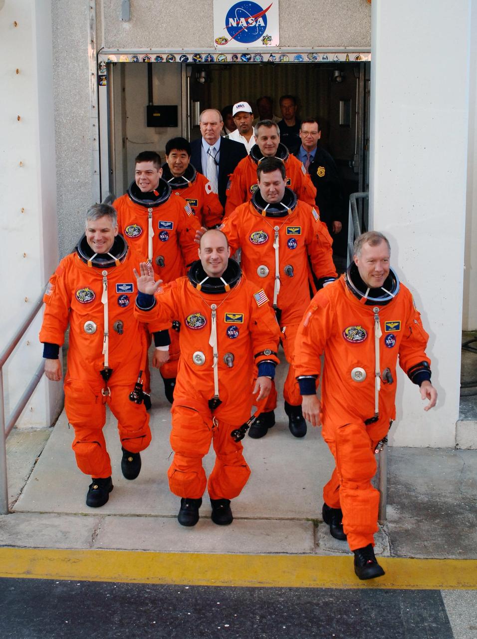 KENNEDY SPACE CENTER, FLA. -- The crew of mission STS-123 eagerly leave the Operations and Checkout Building on their way to NASA Kennedy Space Center's Launch Pad 39A. In front, from left, are Pilot Gregory H. Johnson, Mission Specialist Garrett Reisman and Commander Dominic Gorie. Behind them, from left, are Mission Specialists Robert L. Behnken, Takao Doi, Mike Foreman and Rick Linnehan. The crew is taking part in a simulated launch countdown, the culmination of the terminal countdown demonstration test, or TCDT. The TCDT provides astronauts and ground crews with an opportunity to participate in various simulated countdown activities, including equipment familiarization and emergency training. Space shuttle Endeavour is targeted to launch March 11 at 2:28 a.m. EDT on the 16-day STS-123 mission to the International Space Station. Endeavour and its crew will deliver the first section of the Japan Aerospace Exploration Agency's Kibo laboratory and the Canadian Space Agency's two-armed robotic system, Dextre. Photo credit: NASA/Kim Shiflett