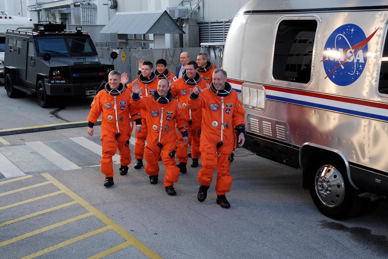 KENNEDY SPACE CENTER, FLA. --  The crew of mission STS-123 waves to spectators as they head for the Astrovan to take them to NASA Kennedy Space Center's Launch Pad 39A. In front, from left, are Pilot Gregory H. Johnson, Mission Specialist Garrett Reisman and Commander Dominic Gorie.  Behind them, from left, are Mission Specialists Robert L. Behnken, Takao Doi, Mike Foreman and Rick Linnehan.  The crew is taking part in a simulated launch countdown, the culmination of the terminal countdown demonstration test, or TCDT.  The TCDT provides astronauts and ground crews with an opportunity to participate in various simulated countdown activities, including equipment familiarization and emergency training. Space shuttle Endeavour is targeted to launch March 11 at 2:28 a.m. EDT on the 16-day STS-123 mission to the International Space Station.  Endeavour and its crew will deliver the first section of the Japan Aerospace Exploration Agency's Kibo laboratory and the Canadian Space Agency's two-armed robotic system, Dextre.   Photo credit: NASA/Kim Shiflett