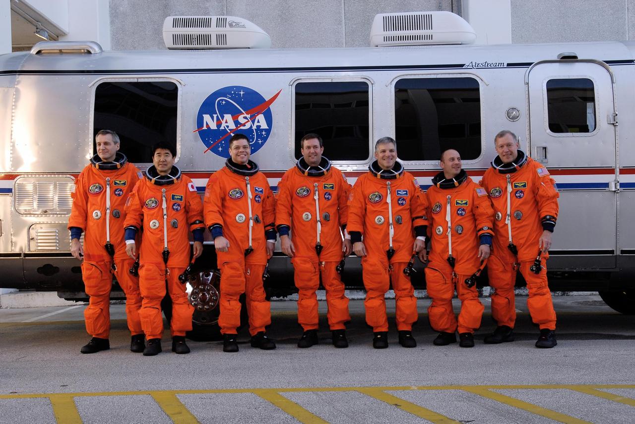 KENNEDY SPACE CENTER, FLA. --  The crew of mission STS-123 provides a photo opportunity in front of the Astrovan for spectators before heading out to NASA Kennedy Space Center's Launch Pad 39A.  From left are Mission Specialists Rick Linnehan, Takao Doi, Robert L. Behnken and Mike Foreman, Pilot Gregory H. Johnson, Mission Specialist Garrett Reisman and Commander Dominic Gorie. The crew is taking part in a simulated launch countdown, the culmination of the terminal countdown demonstration test, or TCDT.   The TCDT provides astronauts and ground crews with an opportunity to participate in various simulated countdown activities, including equipment familiarization and emergency training. Space shuttle Endeavour is targeted to launch March 11 at 2:28 a.m. EDT on the 16-day STS-123 mission to the International Space Station.  Endeavour and its crew will deliver the first section of the Japan Aerospace Exploration Agency's Kibo laboratory and the Canadian Space Agency's two-armed robotic system, Dextre.   Photo credit: NASA/Kim Shiflett