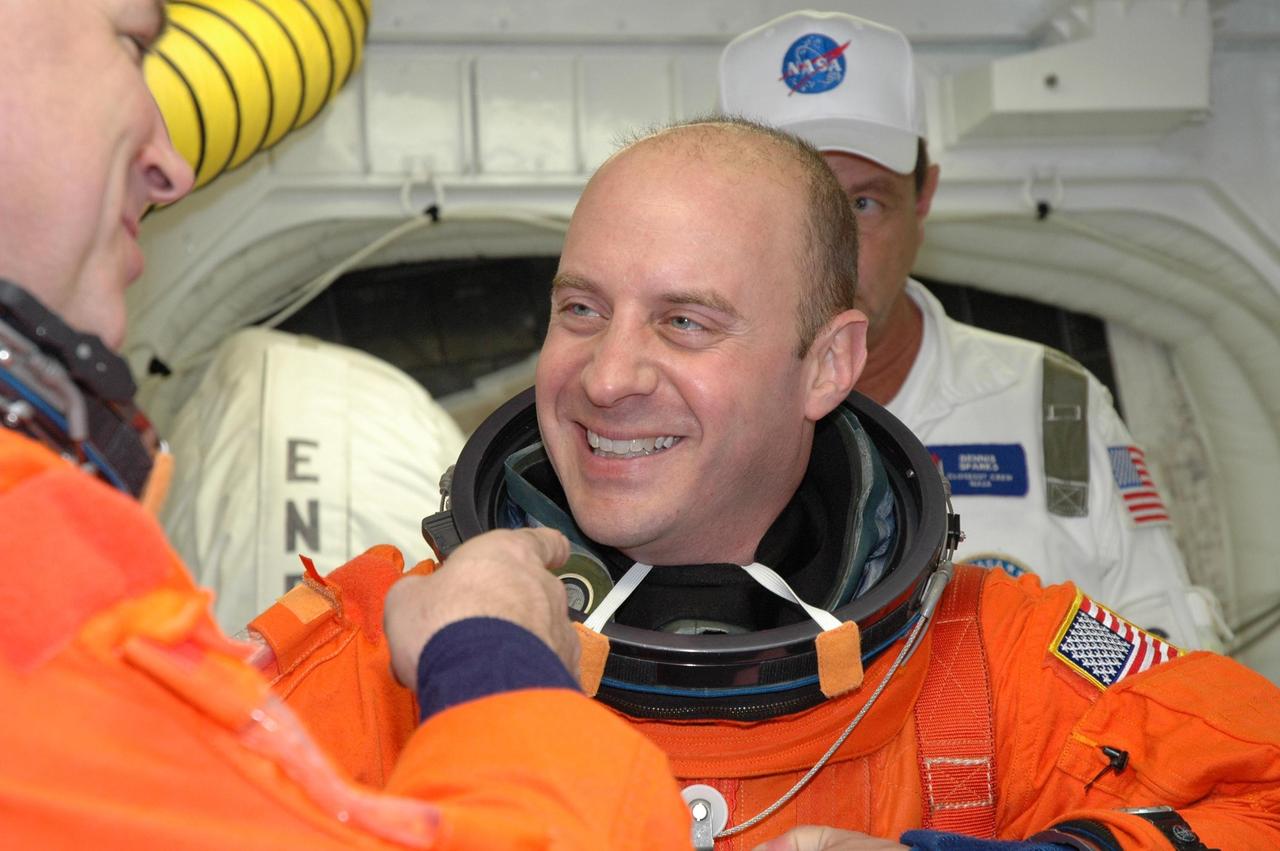 KENNEDY SPACE CENTER, FLA. --  STS-123 Mission Specialist Garrett Reisman is helped with his launch and entry suit before entering space shuttle Endeavour for the simulated launch countdown.  The countdown is the culmination of the terminal countdown demonstration test, or TCDT. The TCDT provides astronauts and ground crews with an opportunity to participate in various countdown activities, including equipment familiarization and emergency egress training. Endeavour is targeted to launch at 2:28 a.m. EDT March 11 on the 16-day STS-123 mission to the International Space Station.  Endeavour and its crew will deliver the first section of the Japan Aerospace Exploration Agency's Kibo laboratory and the Canadian Space Agency's two-armed robotic system, Dextre.   Photo credit: NASA/Jim Grossmann
