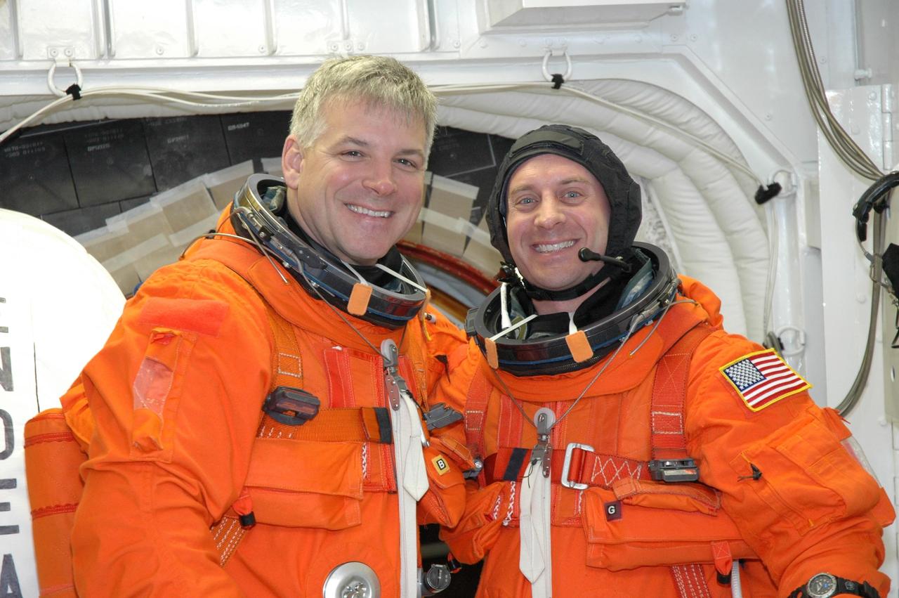 KENNEDY SPACE CENTER, FLA. --  In the White Room on NASA Kennedy Space Center's Launch Pad 39A, STS-123 Pilot Gregory H. Johnson and Mission Specialist Garrett Reisman pause in front of space shuttle Endeavour's open hatch.  They are getting ready to enter Endeavour for the simulated launch countdown, which is the culmination of the terminal countdown demonstration test, or TCDT. The TCDT provides astronauts and ground crews with an opportunity to participate in various countdown activities, including equipment familiarization and emergency egress training. Endeavour is targeted to launch at 2:28 a.m. EDT March 11 on the 16-day STS-123 mission to the International Space Station.  Endeavour and its crew will deliver the first section of the Japan Aerospace Exploration Agency's Kibo laboratory and the Canadian Space Agency's two-armed robotic system, Dextre.   Photo credit: NASA/Jim Grossmann