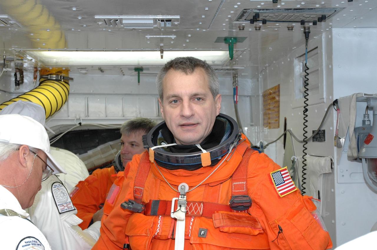 KENNEDY SPACE CENTER, FLA. --  In the White Room on NASA Kennedy Space Center's Launch Pad 39A, STS-123 Mission Specialist Rick Linnehan is getting ready to enter space shuttle Endeavour for the simulated launch countdown. Behind him is Mission Specialist Pilot Gregory H. Johnson.  The countdown is the culmination of the terminal countdown demonstration test, or TCDT. The TCDT provides astronauts and ground crews with an opportunity to participate in various countdown activities, including equipment familiarization and emergency egress training. Endeavour is targeted to launch at 2:28 a.m. EDT March 11 on the 16-day STS-123 mission to the International Space Station.  Endeavour and its crew will deliver the first section of the Japan Aerospace Exploration Agency's Kibo laboratory and the Canadian Space Agency's two-armed robotic system, Dextre.   Photo credit: NASA/Jim Grossmann