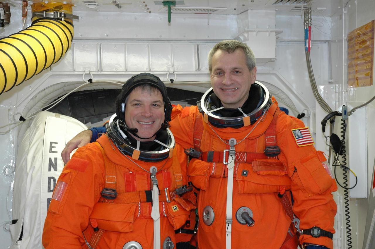 KENNEDY SPACE CENTER, FLA. --  In the White Room on NASA Kennedy Space Center's Launch Pad 39A, STS-123 Pilot Gregory H. Johnson (left) and Mission Specialist Rick Linnehan pause in front space shuttle Endeavour's open hatch.  They are getting ready to enter Endeavour for the simulated launch countdown, which is the culmination of the terminal countdown demonstration test, or TCDT.  The TCDT provides astronauts and ground crews with an opportunity to participate in various countdown activities, including equipment familiarization and emergency egress training. Endeavour is targeted to launch at 2:28 a.m. EDT March 11 on the 16-day STS-123 mission to the International Space Station.  Endeavour and its crew will deliver the first section of the Japan Aerospace Exploration Agency's Kibo laboratory and the Canadian Space Agency's two-armed robotic system, Dextre.   Photo credit: NASA/Jim Grossmann