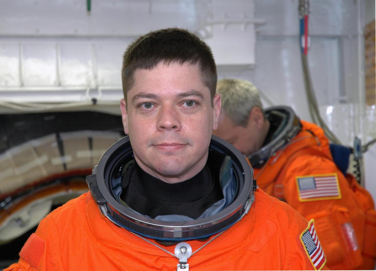 KENNEDY SPACE CENTER, FLA. -- In the White Room on NASA Kennedy Space Center's Launch Pad 39A, STS-123 Mission Specialist Robert L. Behnken is waiting for help with his launch and entry suit before entering space shuttle Endeavour. He and other crew members are getting ready for the simulated launch countdown, which is the culmination of the terminal countdown demonstration test, or TCDT. The TCDT provides astronauts and ground crews with an opportunity to participate in various countdown activities, including equipment familiarization and emergency egress training. Endeavour is targeted to launch at 2:28 a.m. EDT March 11 on the 16-day STS-123 mission to the International Space Station. Endeavour and its crew will deliver the first section of the Japan Aerospace Exploration Agency's Kibo laboratory and the Canadian Space Agency's two-armed robotic system, Dextre. Photo credit: NASA/Jim Grossmann