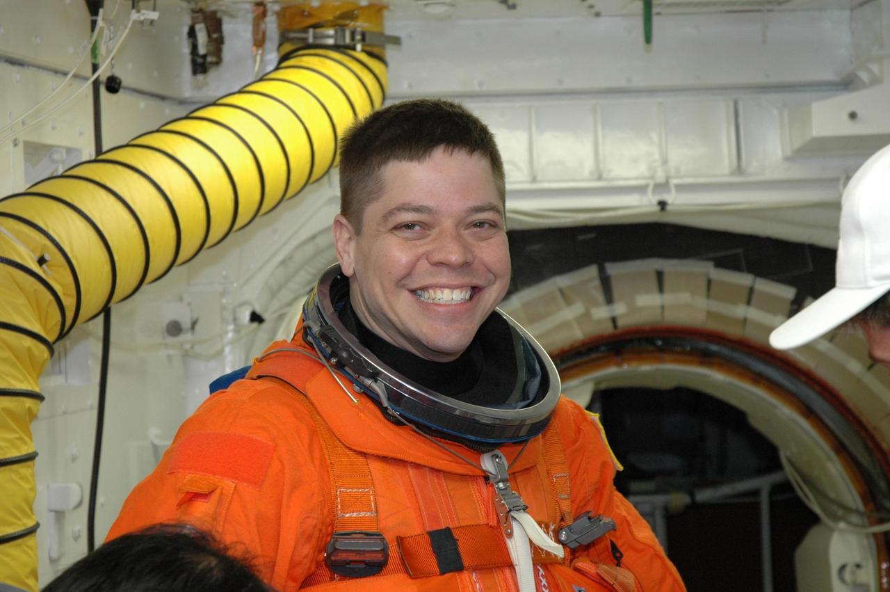 KENNEDY SPACE CENTER, FLA. -- In the White Room on NASA Kennedy Space Center's Launch Pad 39A, STS-123 Mission Specialist Robert L. Behnken is waiting for help with his launch and entry suit before entering space shuttle Endeavour. He and the other STS-123 crew members are getting ready for the simulated launch countdown, which is the culmination of the terminal countdown demonstration test, or TCDT. The TCDT provides astronauts and ground crews with an opportunity to participate in various countdown activities, including equipment familiarization and emergency egress training. Endeavour is targeted to launch at 2:28 a.m. EDT March 11 on the 16-day STS-123 mission to the International Space Station. Endeavour and its crew will deliver the first section of the Japan Aerospace Exploration Agency's Kibo laboratory and the Canadian Space Agency's two-armed robotic system, Dextre. Photo credit: NASA/Jim Grossmann
