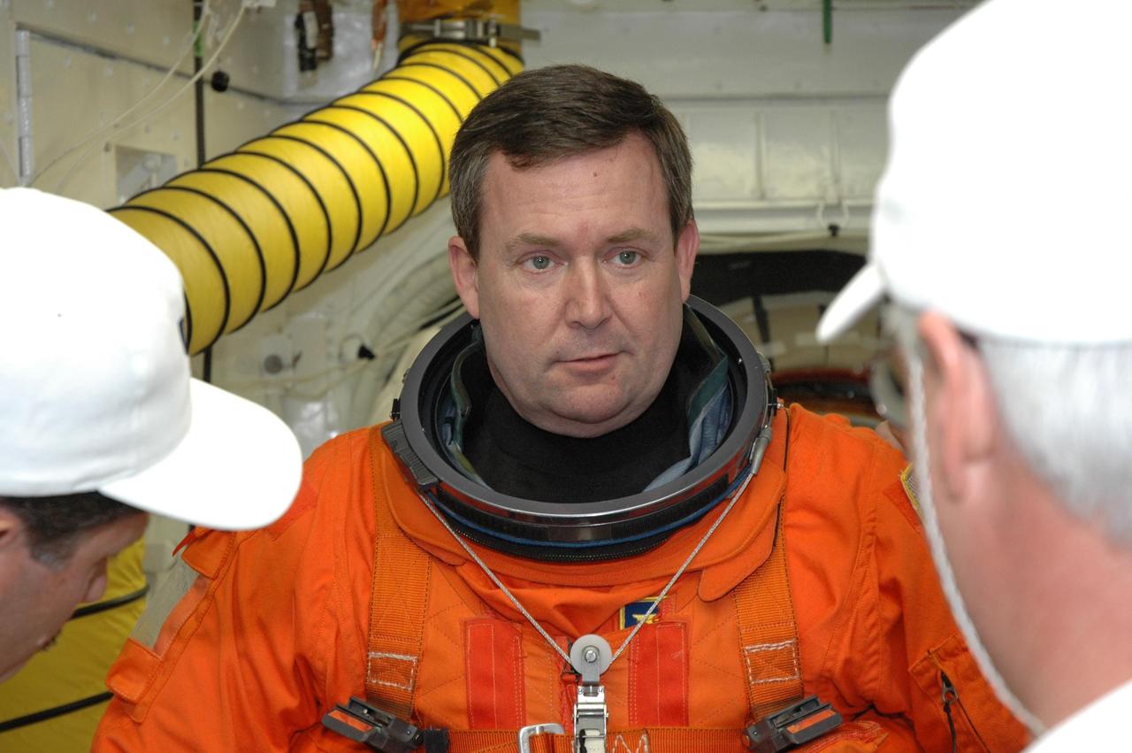 KENNEDY SPACE CENTER, FLA. --  In the White Room on NASA Kennedy Space Center's Launch Pad 39A, STS-123 Mission Specialist Mike Foreman gets help with his launch and entry suit before entering space shuttle Endeavour.  He and the other STS-123 crew members are getting ready for the simulated launch countdown, which is the culmination of the terminal countdown demonstration test, or TCDT.  The TCDT provides astronauts and ground crews with an opportunity to participate in various countdown activities, including equipment familiarization and emergency egress training. Endeavour is targeted to launch at 2:28 a.m. EDT March 11 on the 16-day STS-123 mission to the International Space Station.  Endeavour and its crew will deliver the first section of the Japan Aerospace Exploration Agency's Kibo laboratory and the Canadian Space Agency's two-armed robotic system, Dextre.   Photo credit: NASA/Jim Grossmann