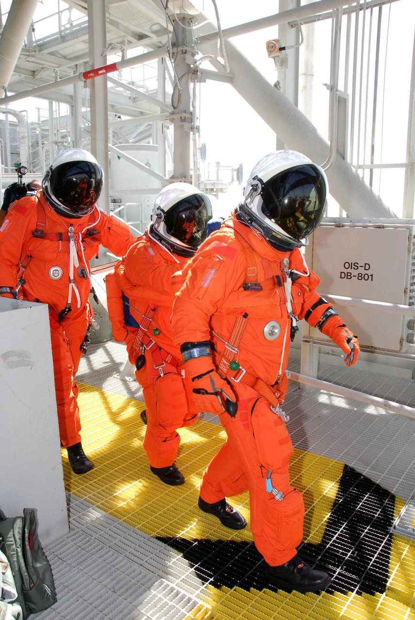 KENNEDY SPACE CENTER, FLA. -- Following the simulated launch countdown, STS-123 crew members head for the slidewire baskets on Launch Pad 39 at NASA's Kennedy Space Center. The crew is practicing emergency egress from the pad. The countdown was the culmination of the terminal countdown demonstration test, or TCDT. The TCDT provides astronauts and ground crews with an opportunity to participate in various countdown activities, including equipment familiarization and emergency egress training. Endeavour is targeted to launch at 2:28 a.m. EDT March 11 on the 16-day STS-123 mission to the International Space Station. Endeavour and its crew will deliver the first section of the Japan Aerospace Exploration Agency's Kibo laboratory and the Canadian Space Agency's two-armed robotic system, Dextre. Photo credit: NASA/Kim Shiflett