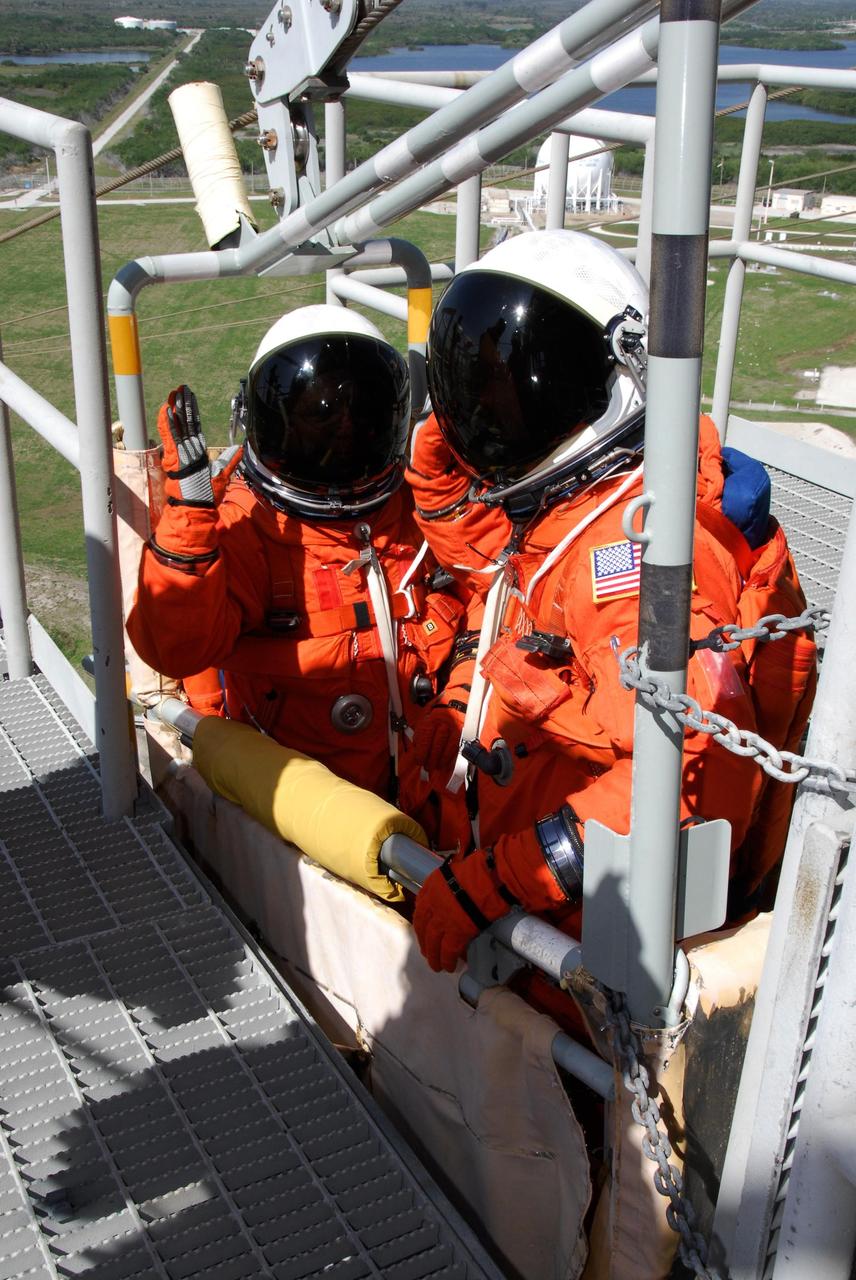 KENNEDY SPACE CENTER, FLA. -- Following the simulated launch countdown, STS-123 crew members settle in a slidewire basket on Launch Pad 39 at NASA's Kennedy Space Center.  The crew is practicing emergency egress from the pad.  The countdown was the culmination of the terminal countdown demonstration test, or TCDT.  The TCDT provides astronauts and ground crews with an opportunity to participate in various countdown activities, including equipment familiarization and emergency egress training. Endeavour is targeted to launch at 2:28 a.m. EDT March 11 on the 16-day STS-123 mission to the International Space Station.  Endeavour and its crew will deliver the first section of the Japan Aerospace Exploration Agency's Kibo laboratory and the Canadian Space Agency's two-armed robotic system, Dextre.   Photo credit: NASA/Kim Shiflett