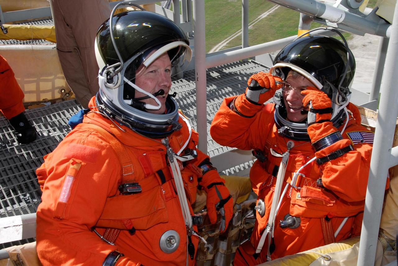 KENNEDY SPACE CENTER, FLA. -- Following the simulated launch countdown, STS-123 Commander Dominic Gorie (left) and Pilot Gregory H. Johnson sit in the slidewire basket, part of emergency egress training. The countdown was the culmination of the terminal countdown demonstration test, or TCDT. The TCDT provides astronauts and ground crews with an opportunity to participate in various countdown activities, including equipment familiarization and emergency egress training. Endeavour is targeted to launch at 2:28 a.m. EDT March 11 on the 16-day STS-123 mission to the International Space Station. Endeavour and its crew will deliver the first section of the Japan Aerospace Exploration Agency's Kibo laboratory and the Canadian Space Agency's two-armed robotic system, Dextre. Photo credit: NASA/Kim Shiflett