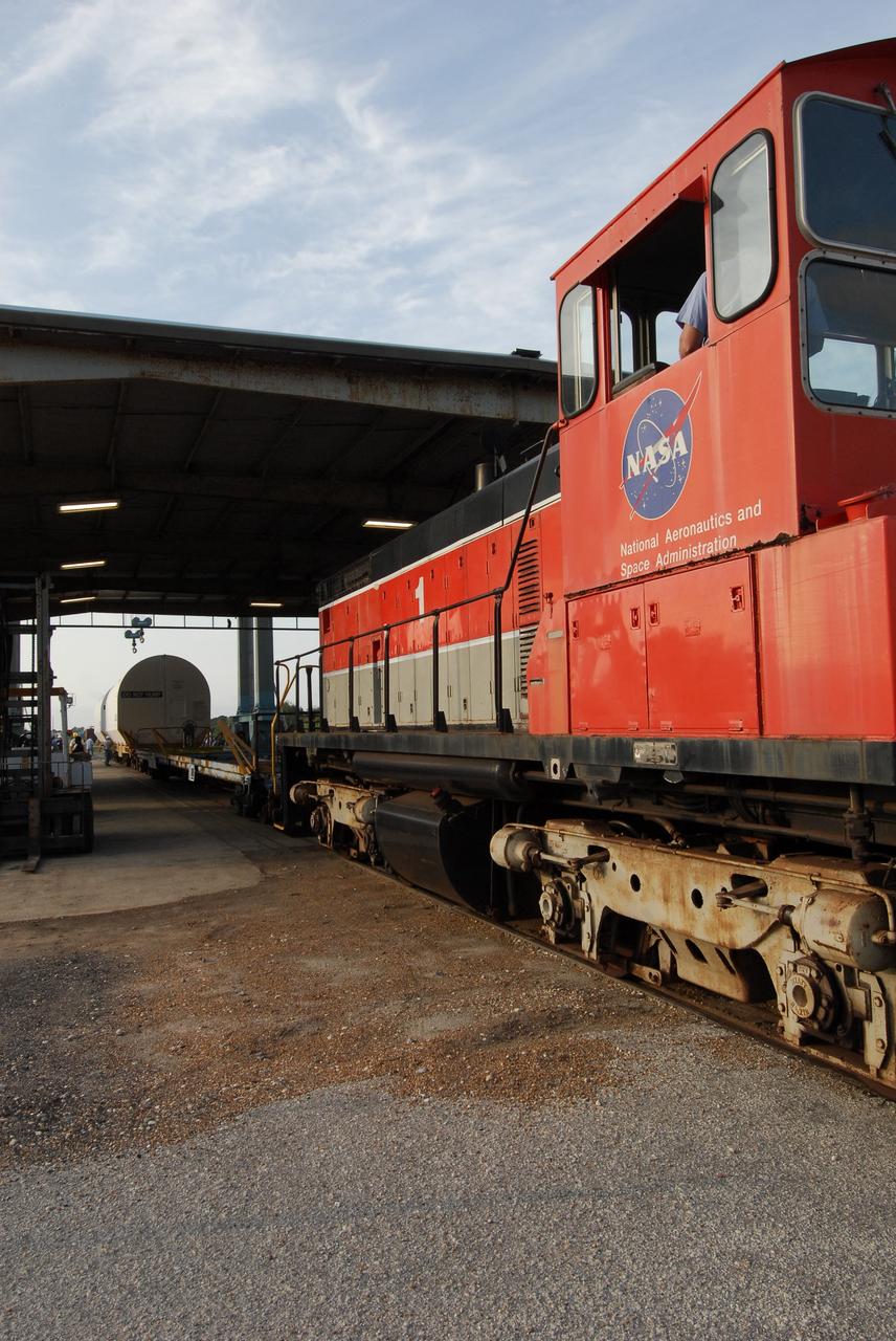KENNEDY SPACE CENTER, FLA. --  A segment of a solid rocket booster from the STS-122 mission is loaded on the NASA Railroad at NASA's Kennedy Space Center.  After a mission, the spent boosters are recovered, cleaned, disassembled, refurbished and reused after each launch. After hydrolasing the interior of each segment, they are placed on flatbed trucks. The individual booster segments are transferred to a railhead located at the railroad yard.  The covered segments will be moved to Titusville for interchange with Florida East Coast Railway to begin the trip back to the Thiokol plant in Wa¬satch, Utah.   Photo credit: NASA/Jack Pfaller