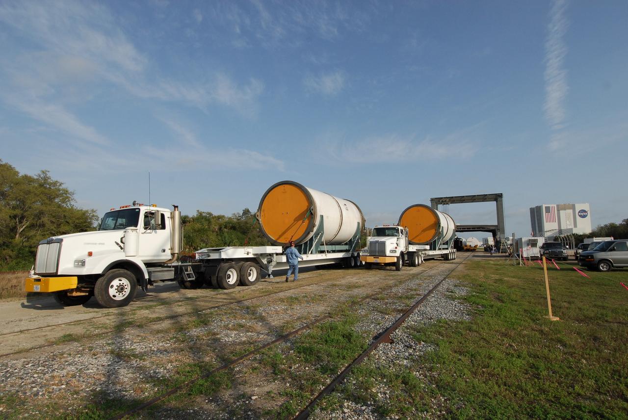 KENNEDY SPACE CENTER, FLA. --    Spent segments of the solid rocket boosters from the STS-122 mission arrive at the Railroad yard at NASA's Kennedy Space Center.  The segments will be loaded onto the railroad cars for transportation to Utah.  After a mission, the spent boosters are recovered, cleaned, disassembled, refurbished and reused after each launch. After hydrolasing the interior of each segment, they are placed on flatbed trucks. The individual booster segments are transferred to a railhead located at the railroad yard.  The covered segments will be moved to Titusville for interchange with Florida East Coast Railway to begin the trip back to the Thiokol plant in Wa¬satch, Utah.   Photo credit: NASA/Jack Pfaller