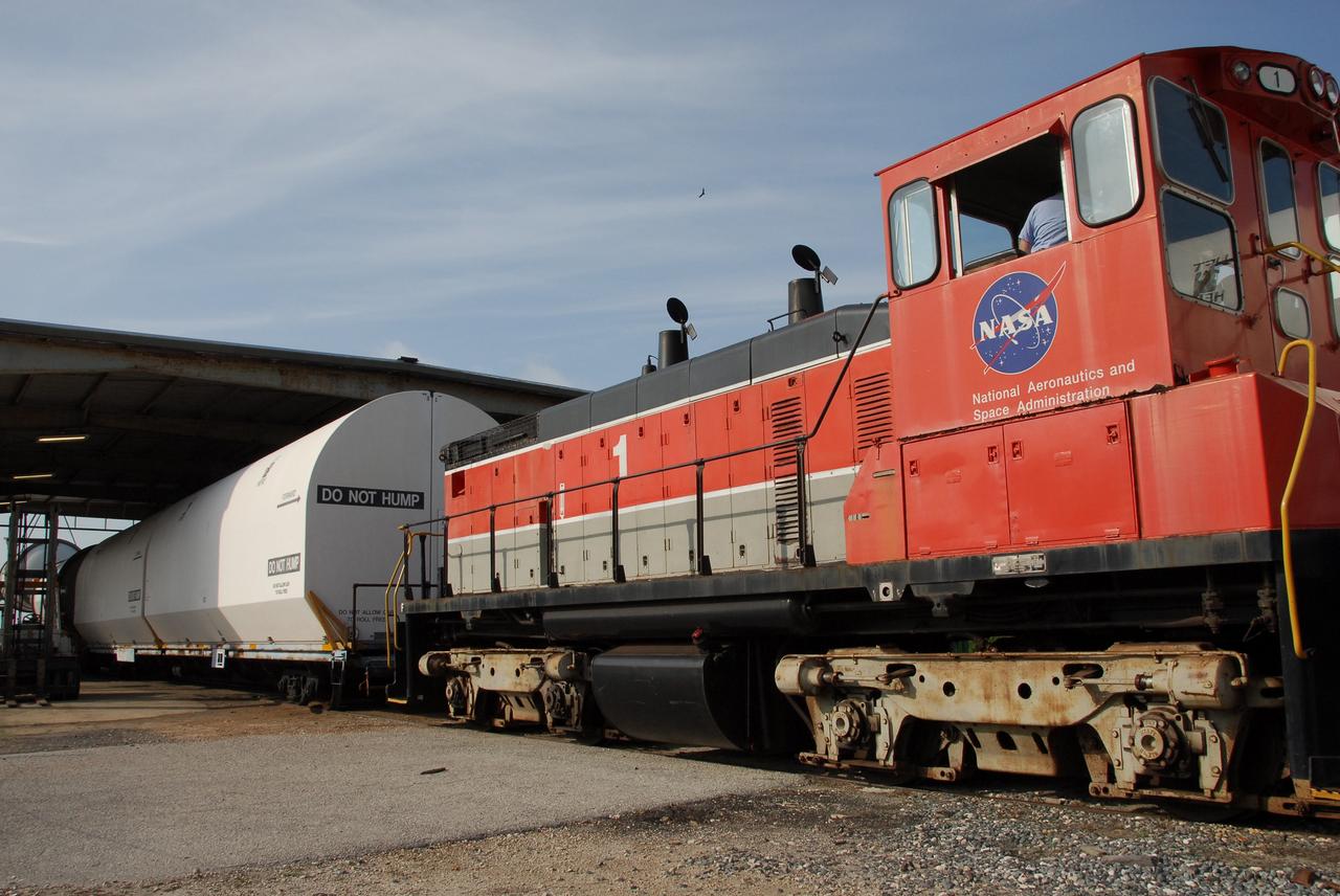 KENNEDY SPACE CENTER, FLA. --  At the Railroad yard at NASA's Kennedy Space Center, solid rocket booster segments from the STS-122 mission are being loaded onto railroad cars and covered for transportation to Utah.  After a mission, the spent boosters are recovered, cleaned, disassembled, refurbished and reused after each launch. After hydrolasing the interior of each segment, they are placed on flatbed trucks. The individual booster segments are transferred to a railhead located at the railroad yard.  The covered segments will be moved to Titusville for interchange with Florida East Coast Railway to begin the trip back to the Thiokol plant in Wa¬satch, Utah.   Photo credit: NASA/Jack Pfaller