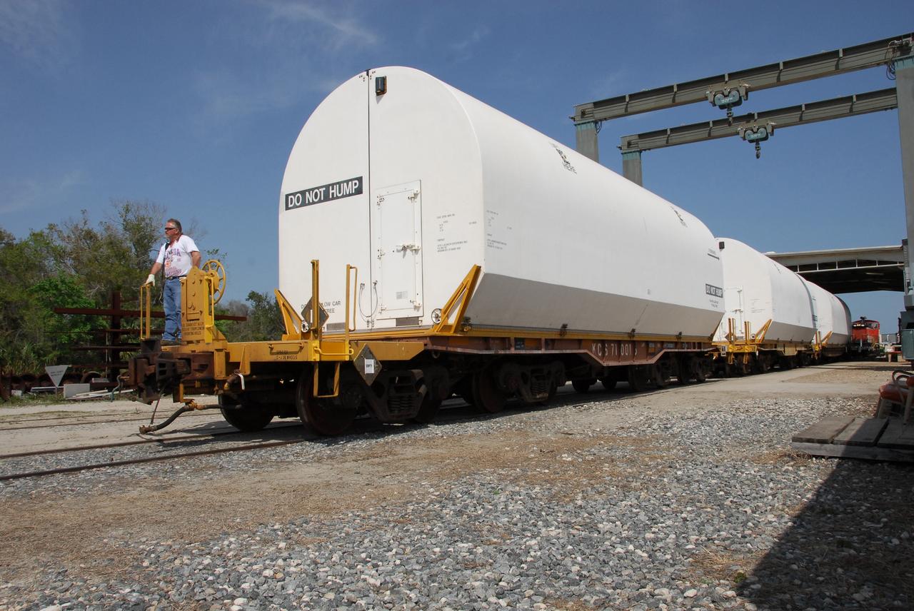 KENNEDY SPACE CENTER, FLA. --  At the NASA Railroad yard at NASA's Kennedy Space Center, all the solid rocket booster segments from the STS-122 mission are covered and secure on the train for transportation to Utah.  After a mission, the spent boosters are recovered, cleaned, disassembled, refurbished and reused after each launch. After hydrolasing the interior of each segment, they are placed on flatbed trucks. The individual booster segments are transferred to a railhead located at the railroad yard.  The covered segments will be moved to Titusville for interchange with Florida East Coast Railway to begin the trip back to the Thiokol plant in Wa¬satch, Utah.   Photo credit: NASA/Jack Pfaller